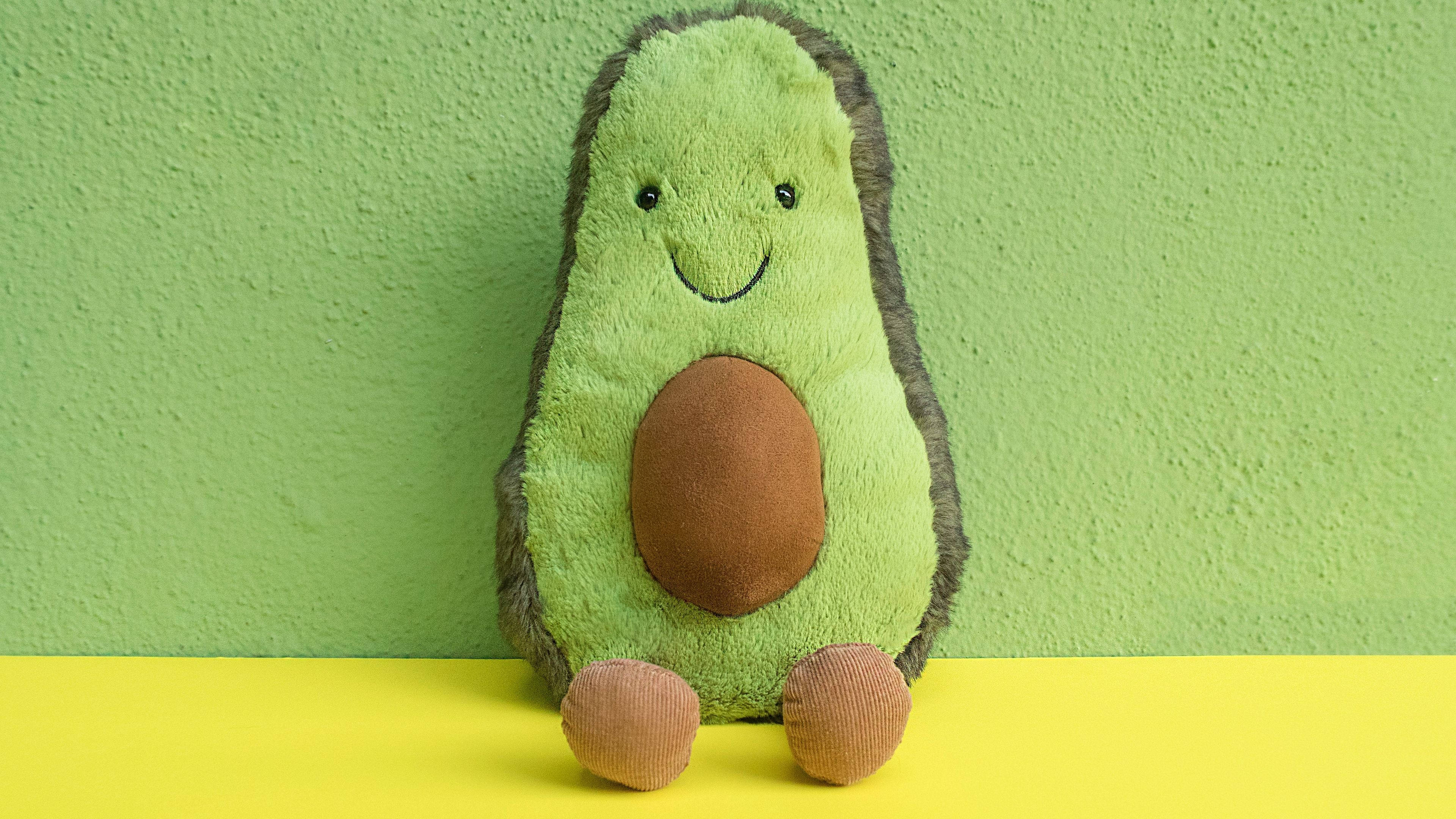 Avokado kosedyr på pastellgrønn Bakgrunner