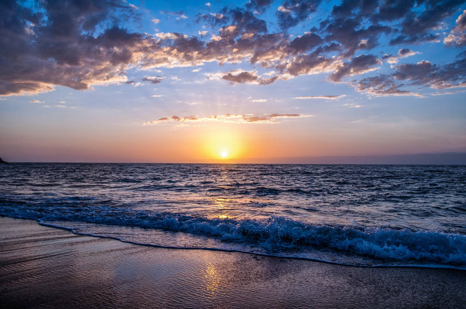 Gratis strand under solnedgang arkivfoto