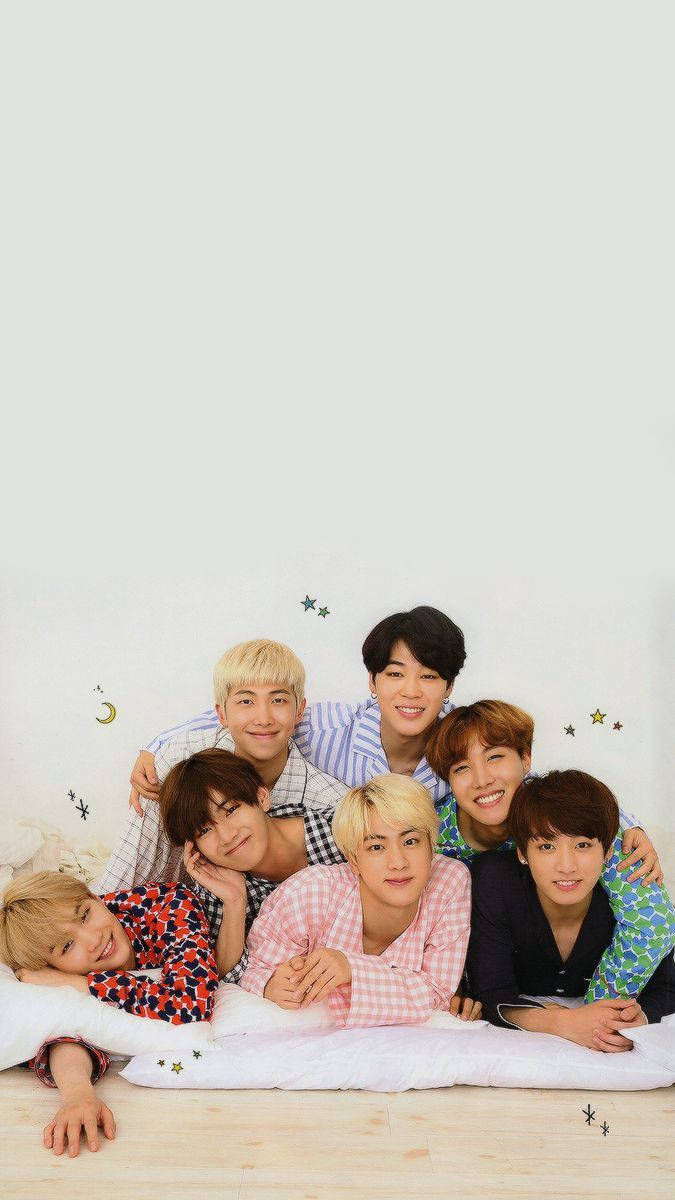 BTS ligger sammen i sengen og smiler bakgrunnsbilde.