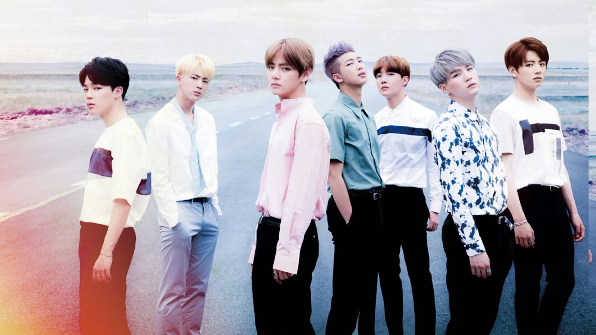 BTS boyband-medlemmer iført kule klær mens de er på veien.