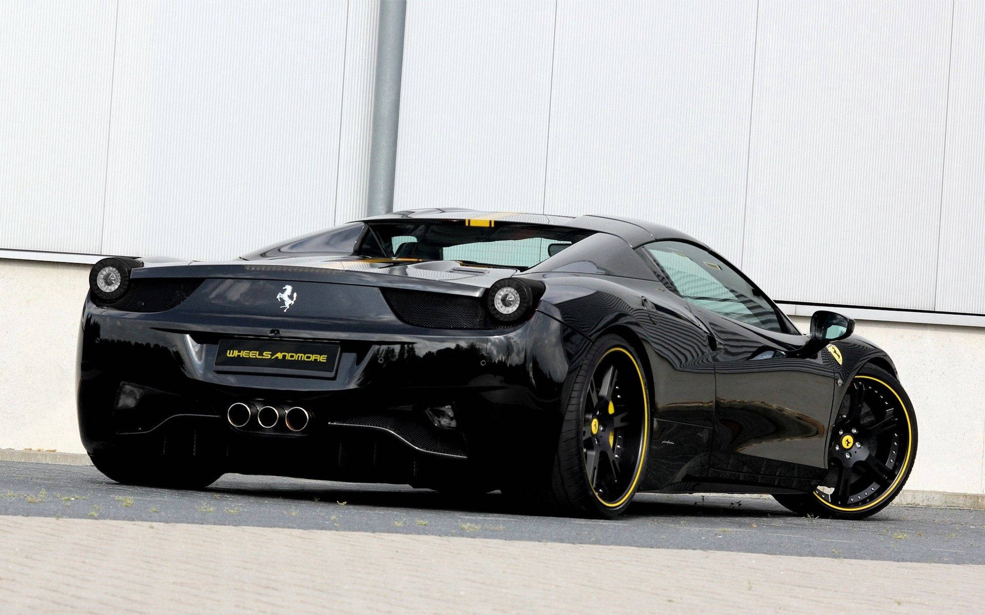 Bakfra av svart Ferrari 458 Italia med gule aksenter bakgrunnsbilde.
