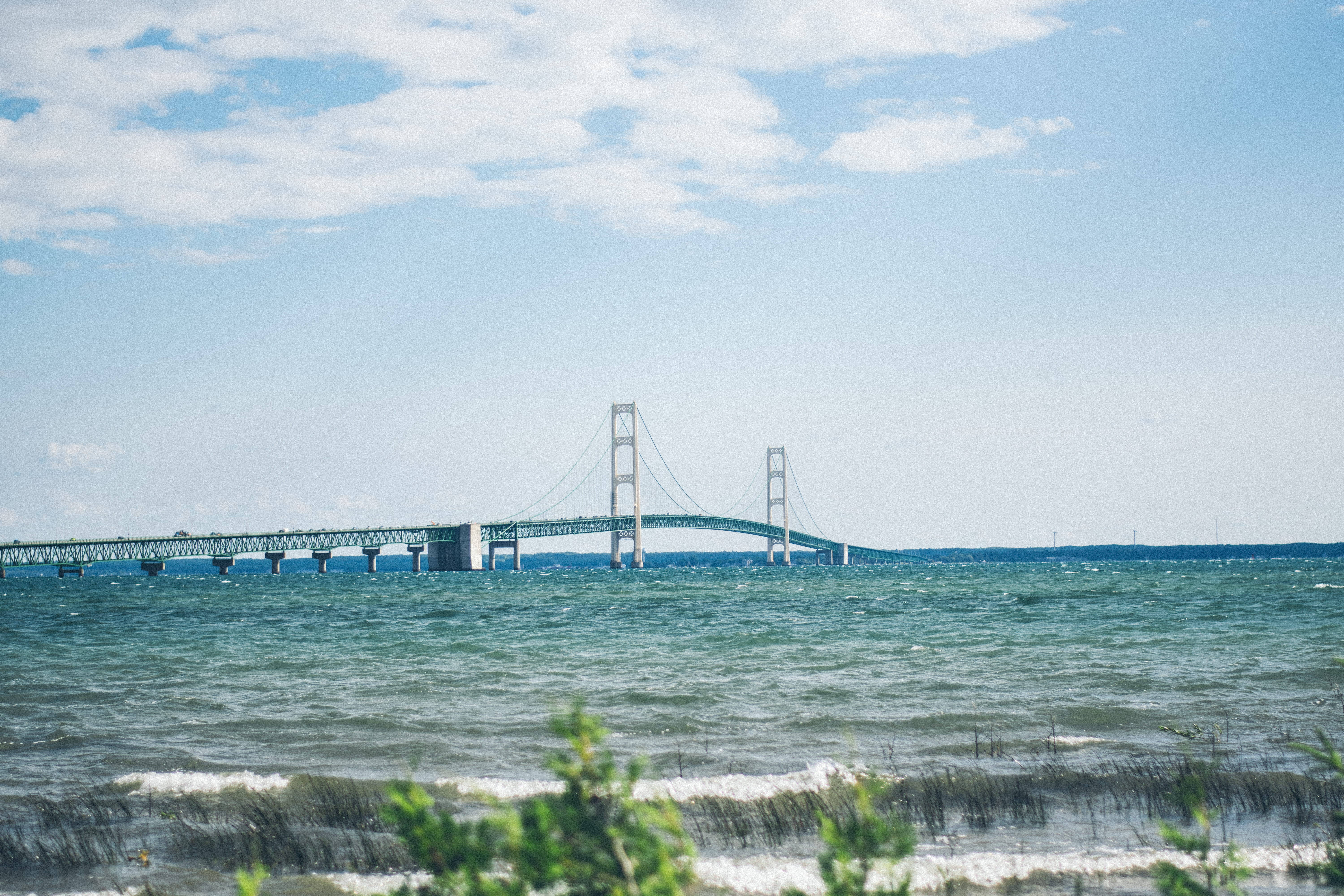 Den majestetiske Mackinac Bridge som strekker seg over det rolige blå vannet Bakgrunner
