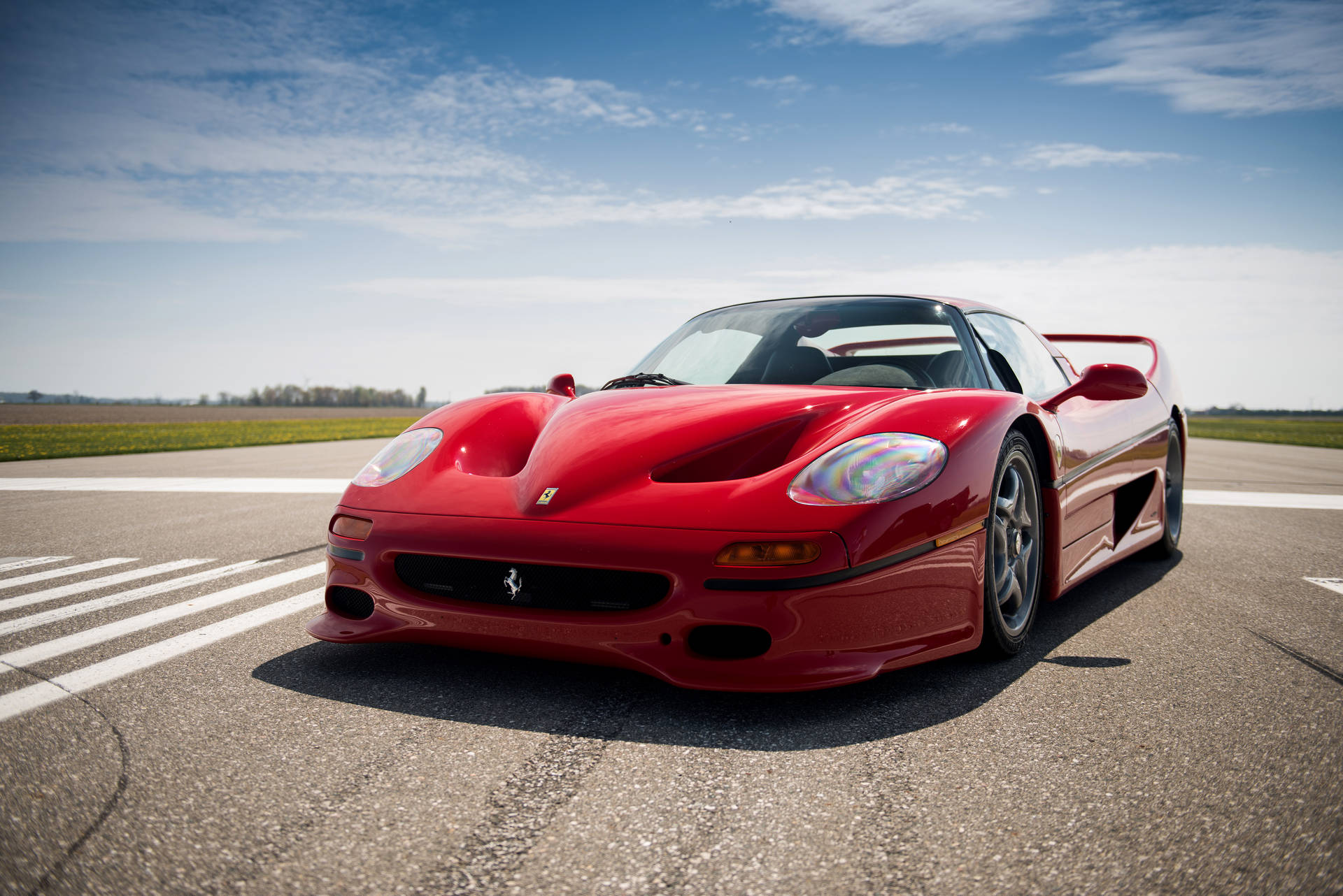 Rød Ferrari F50 ved fotgjengerfelt bakgrunnsbilde.
