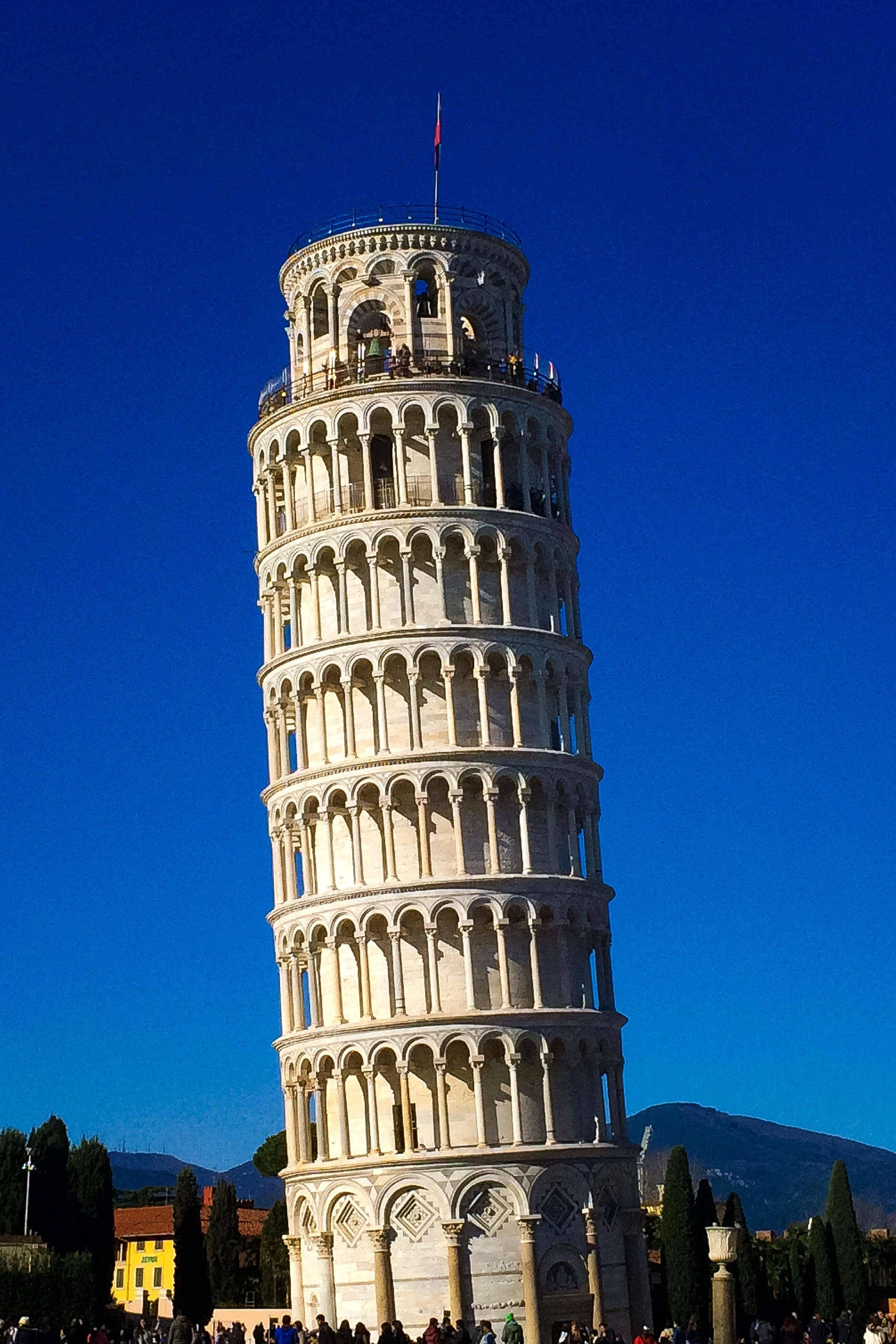 Det skjeve tårnet i Pisa mot mørk blå himmel Bakgrunner