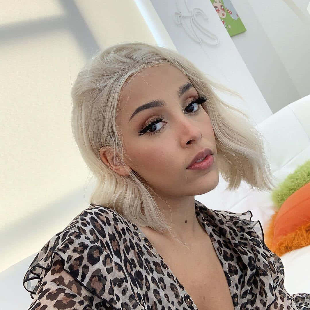 Doja Cat som viser sin skjønnhet med glitterøyenskygge og et lyst smil. Bakgrunner