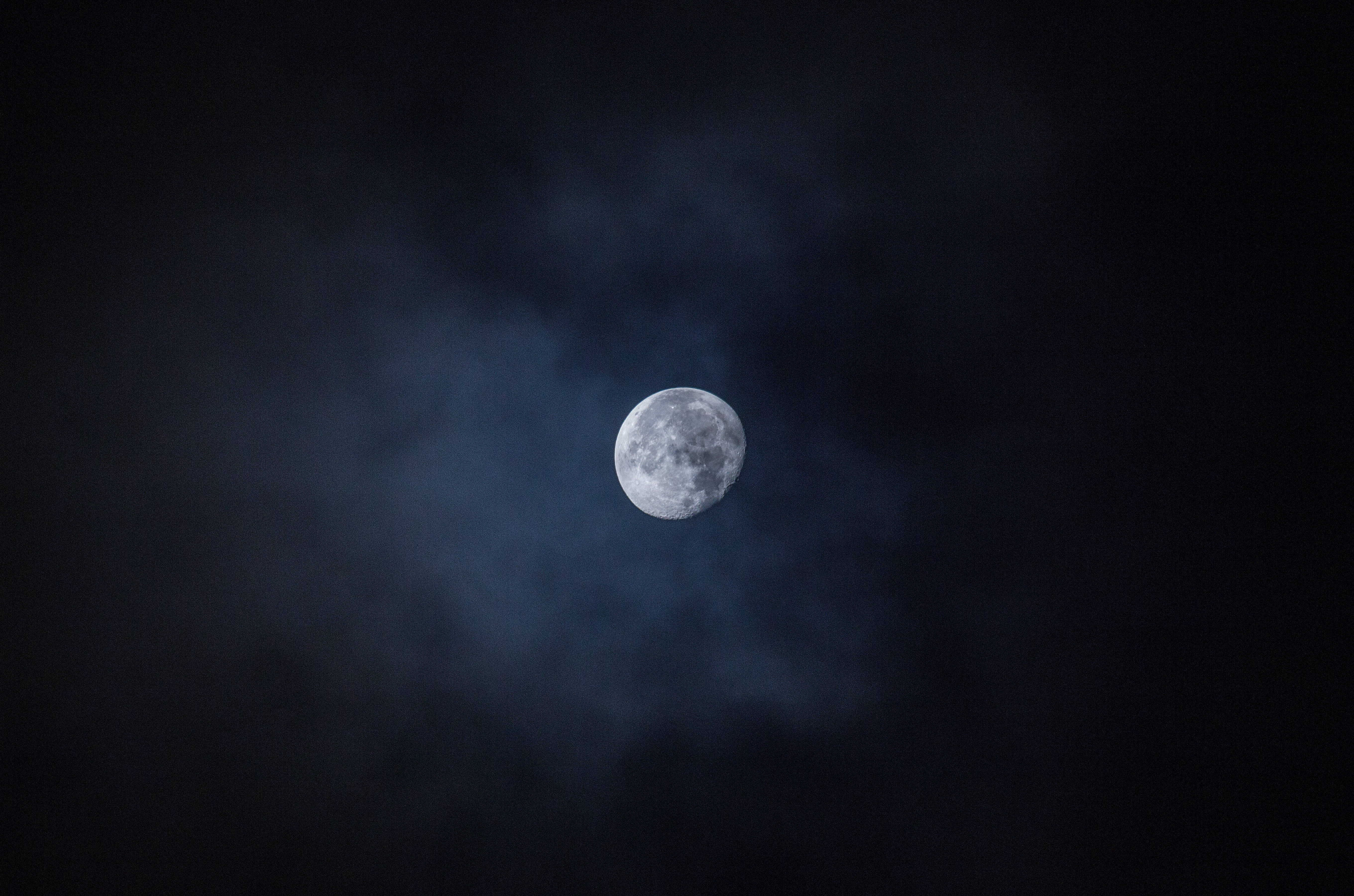 En fascinerende utsikt av månen omgitt av en stjerneklar nattehimmel. Bakgrunner