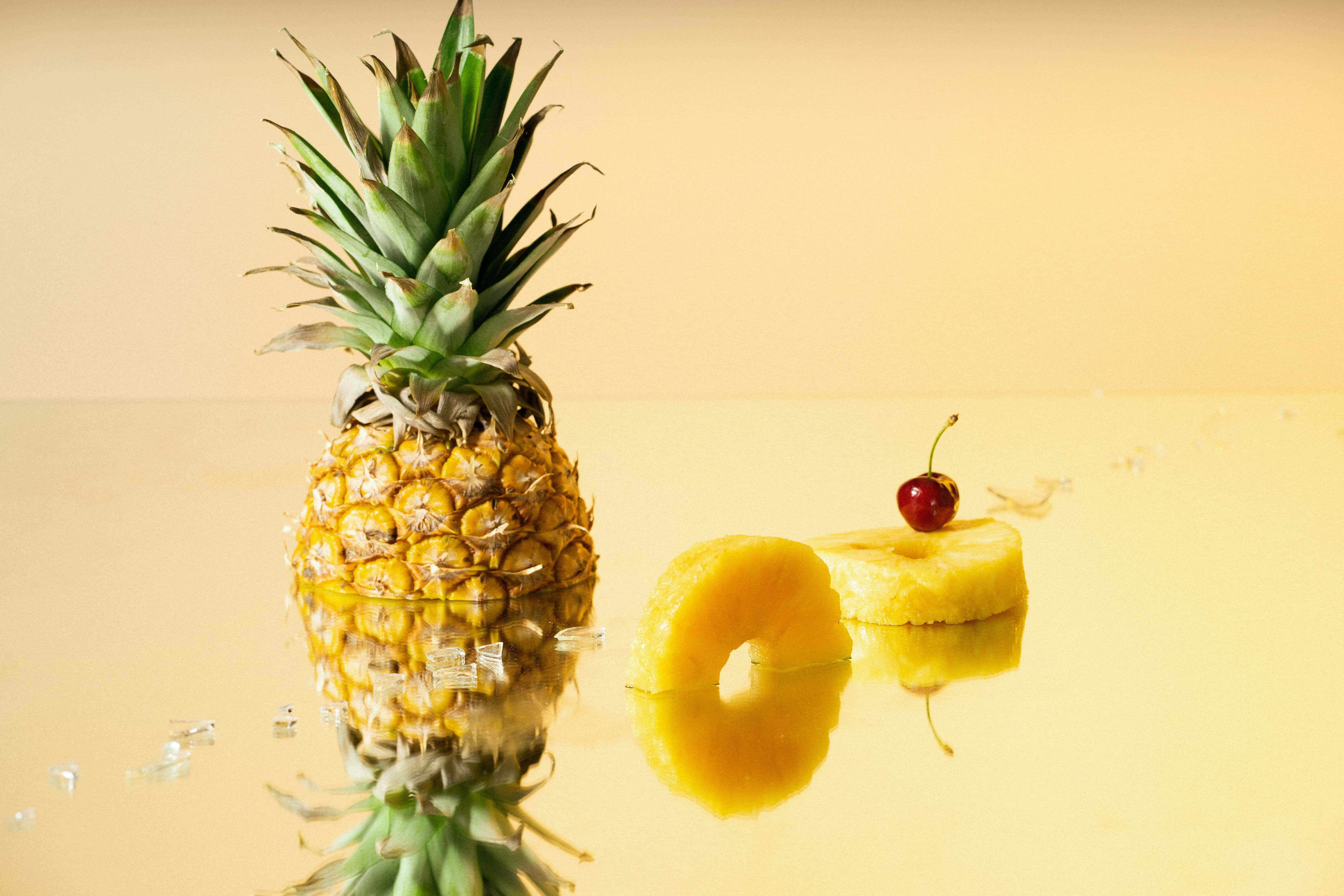 En fersk og saftig ananas står i forgrunnen av en pittoresk solnedgang. Bakgrunner