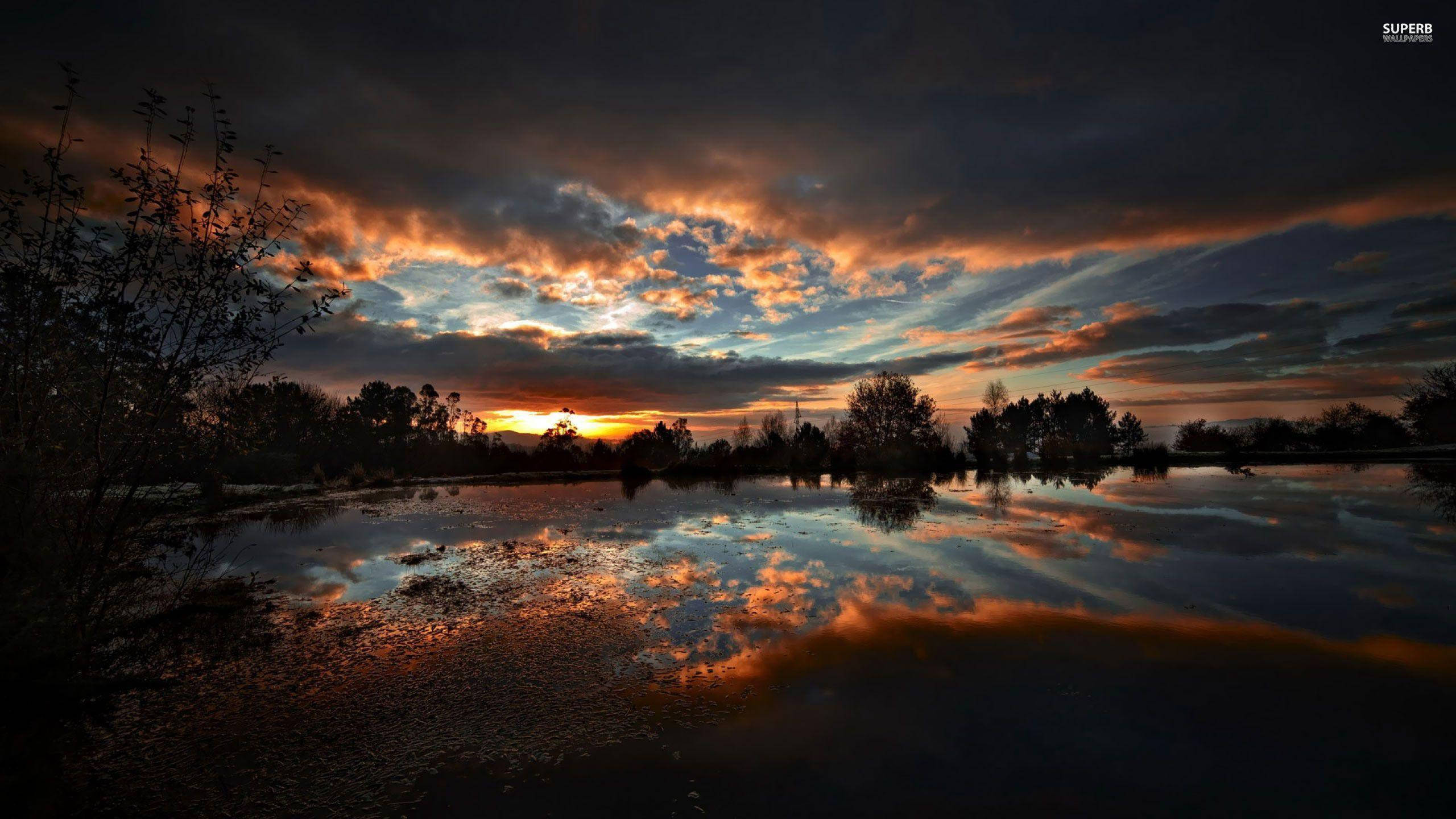 En fredelig og rolig refleksjon av en mørk solnedgang Bakgrunner