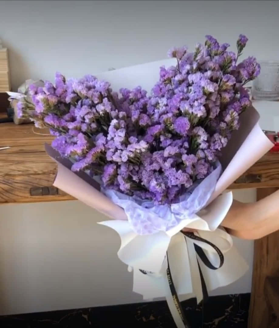 en kvinne holder en bukett med lilla blomster Bakgrunner