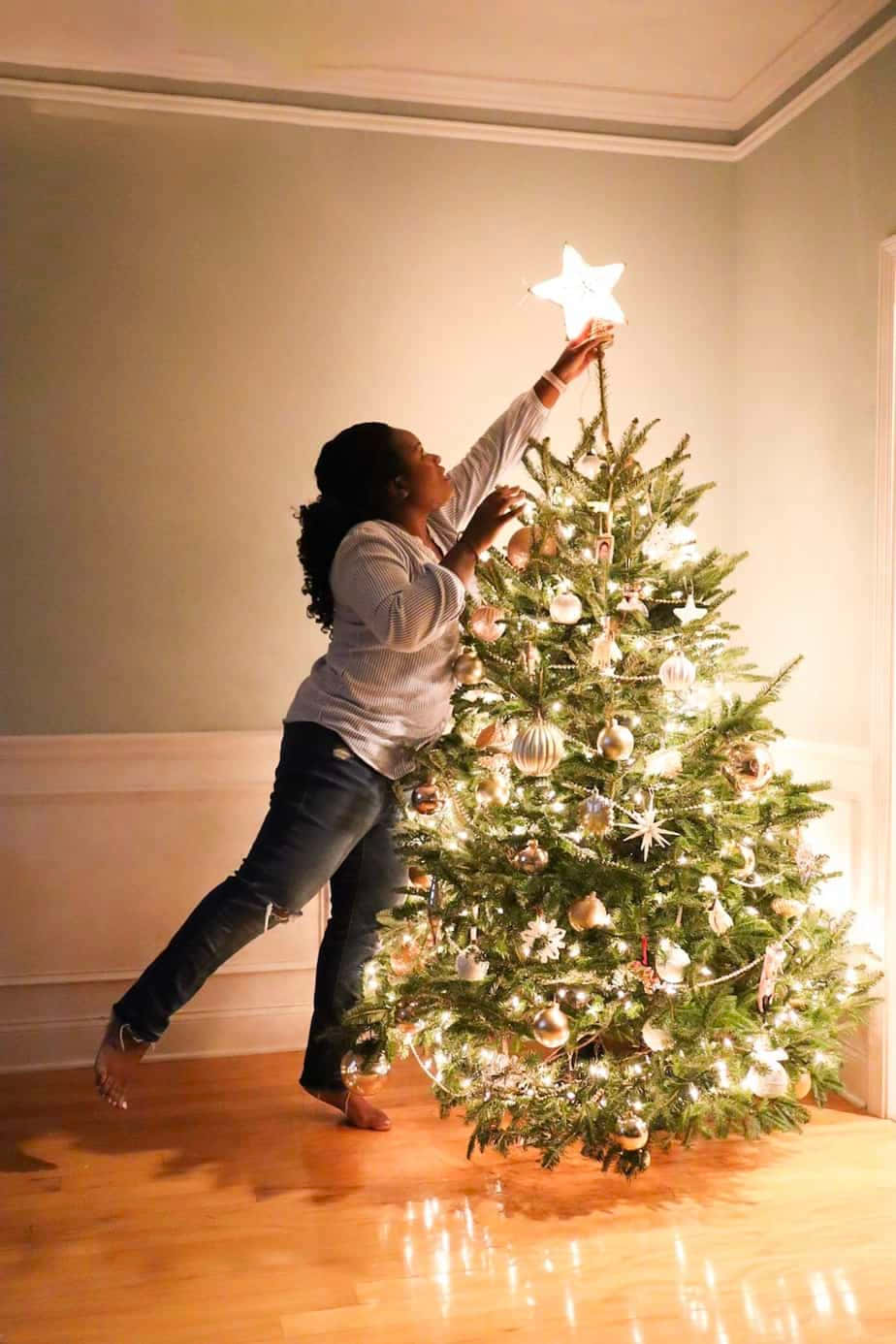 En kvinne setter en stjerne på juletreet Bakgrunner