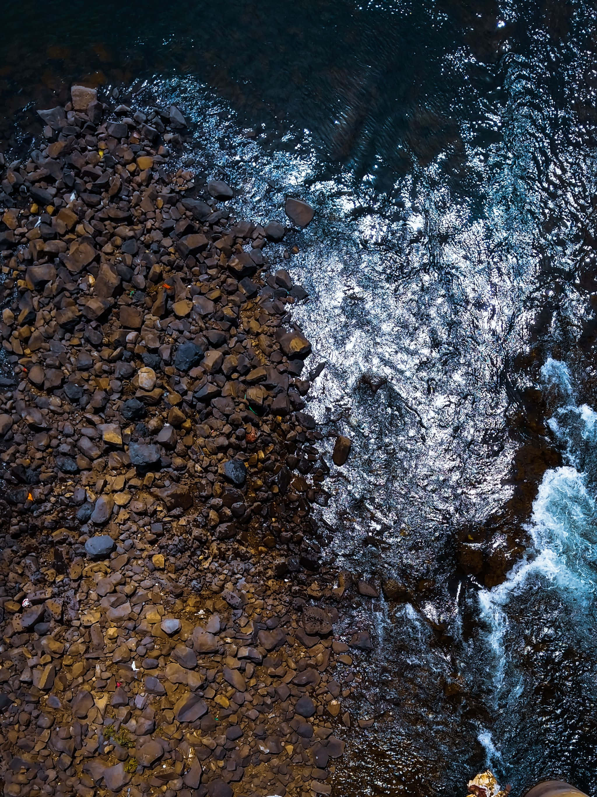 en mann står på en klippe og ser utover vannet Bakgrunner