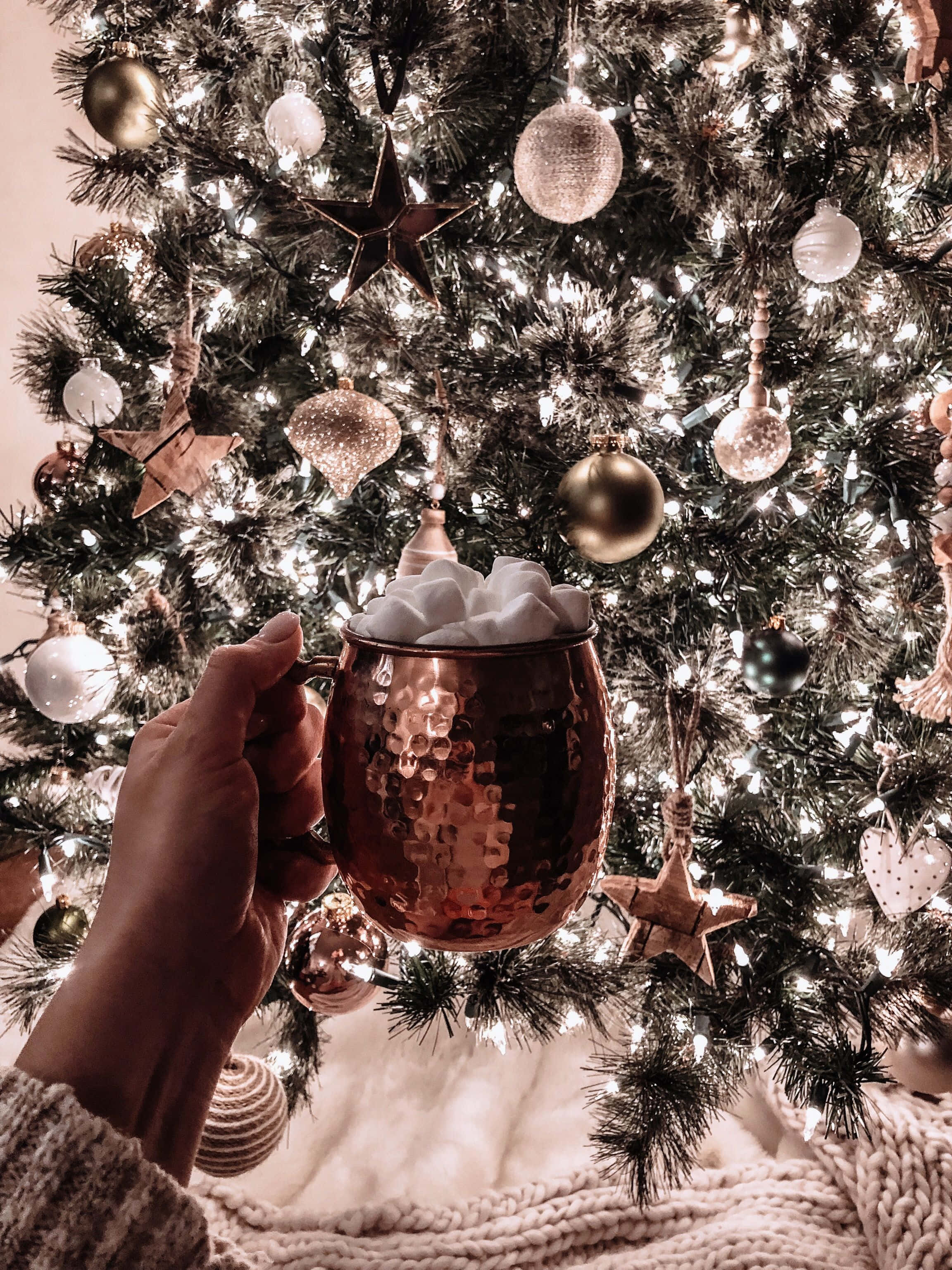 en person som holder en kaffekopp foran et juletre Bakgrunner