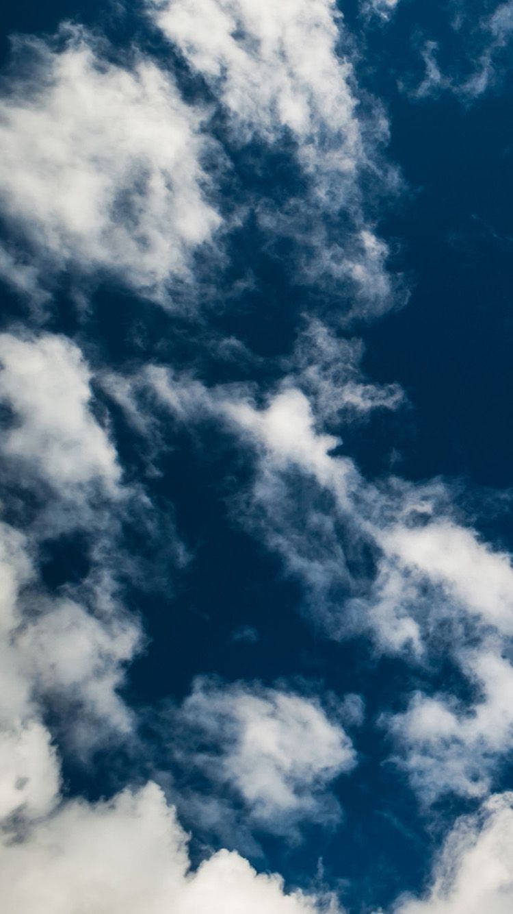 Blå himmel på en skyet dag iPhone-bakgrunn