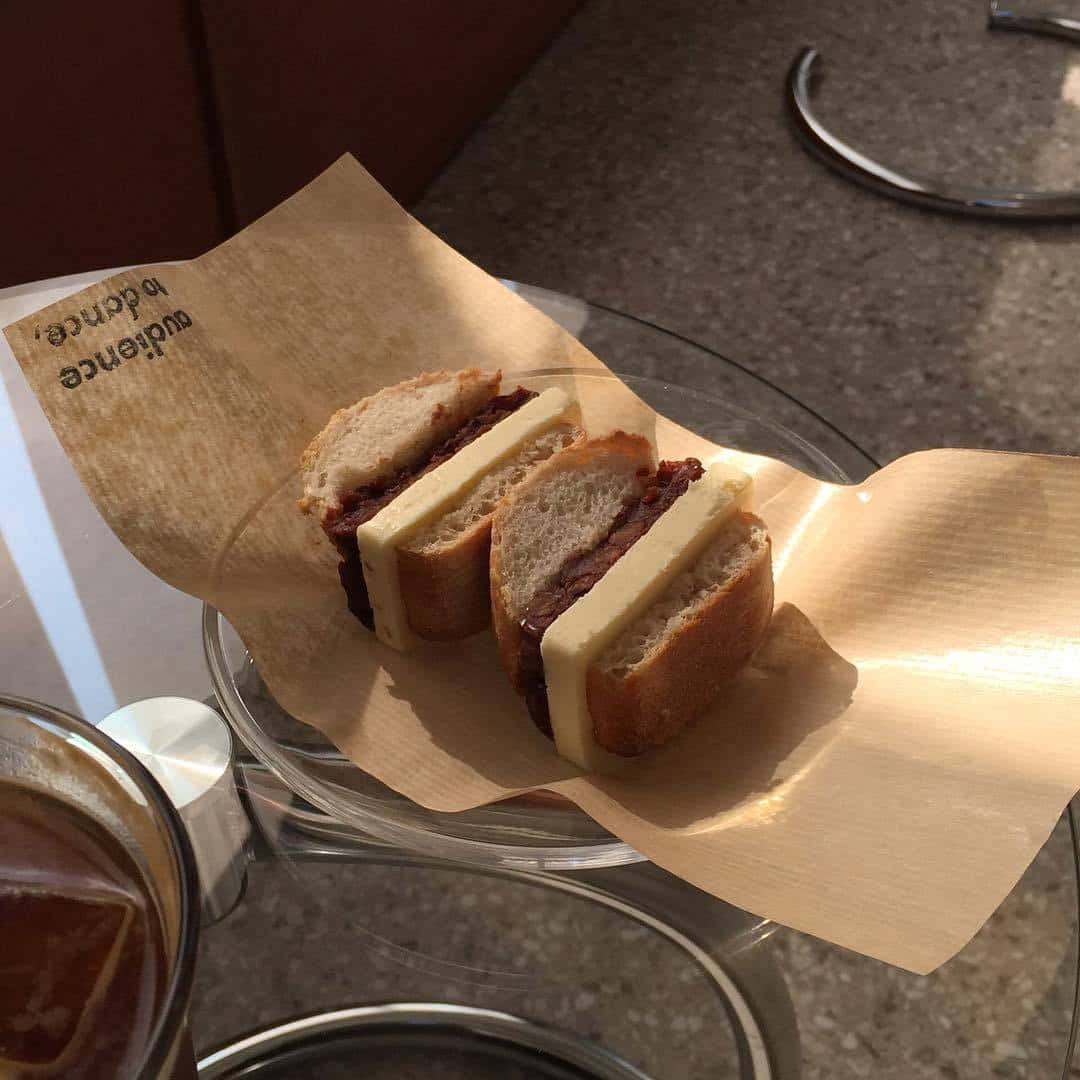 en smørbrød på en tallerken med en kopp kaffe Bakgrunner
