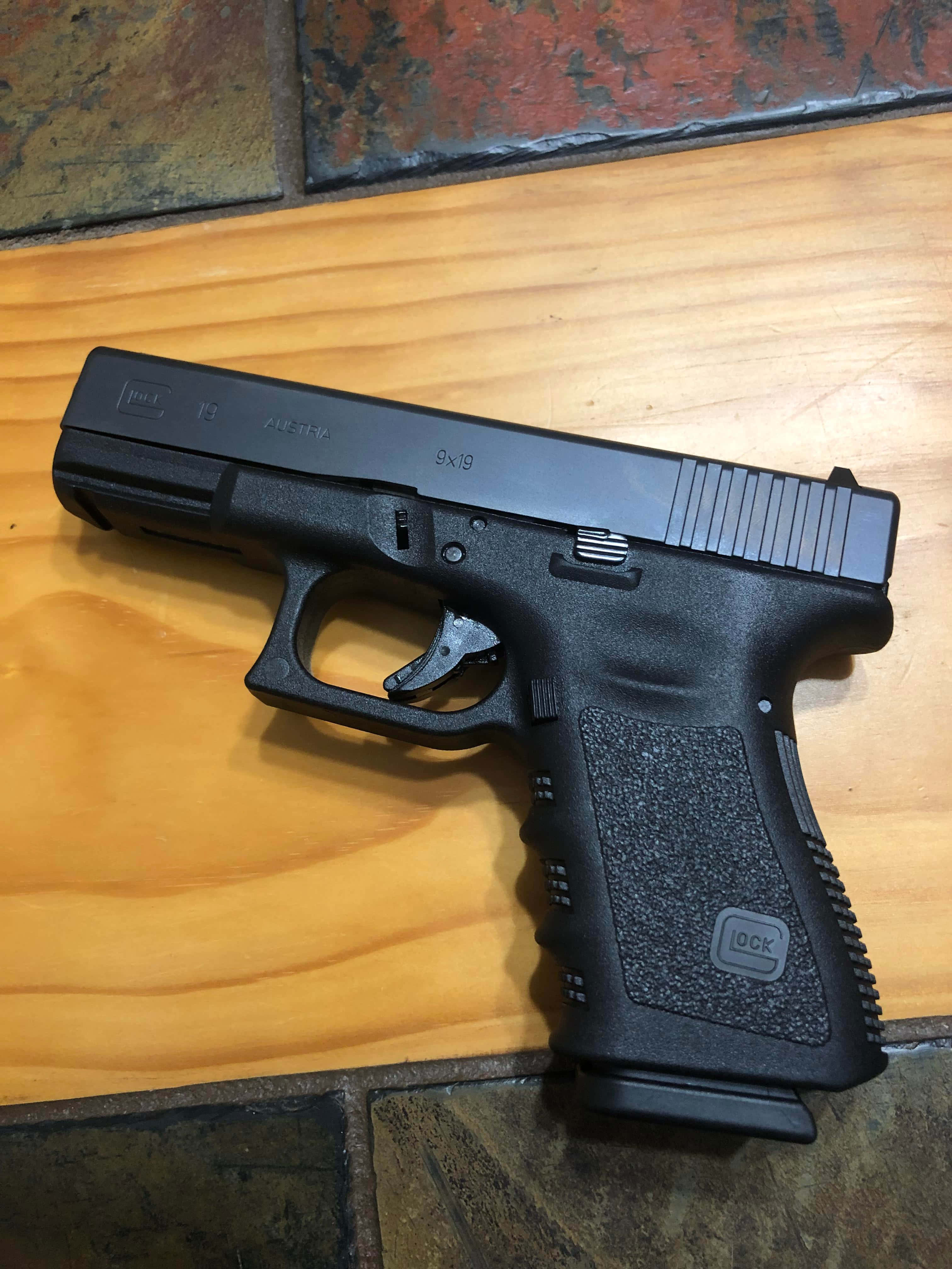 en svart glock-pistol på et tregulv Bakgrunner