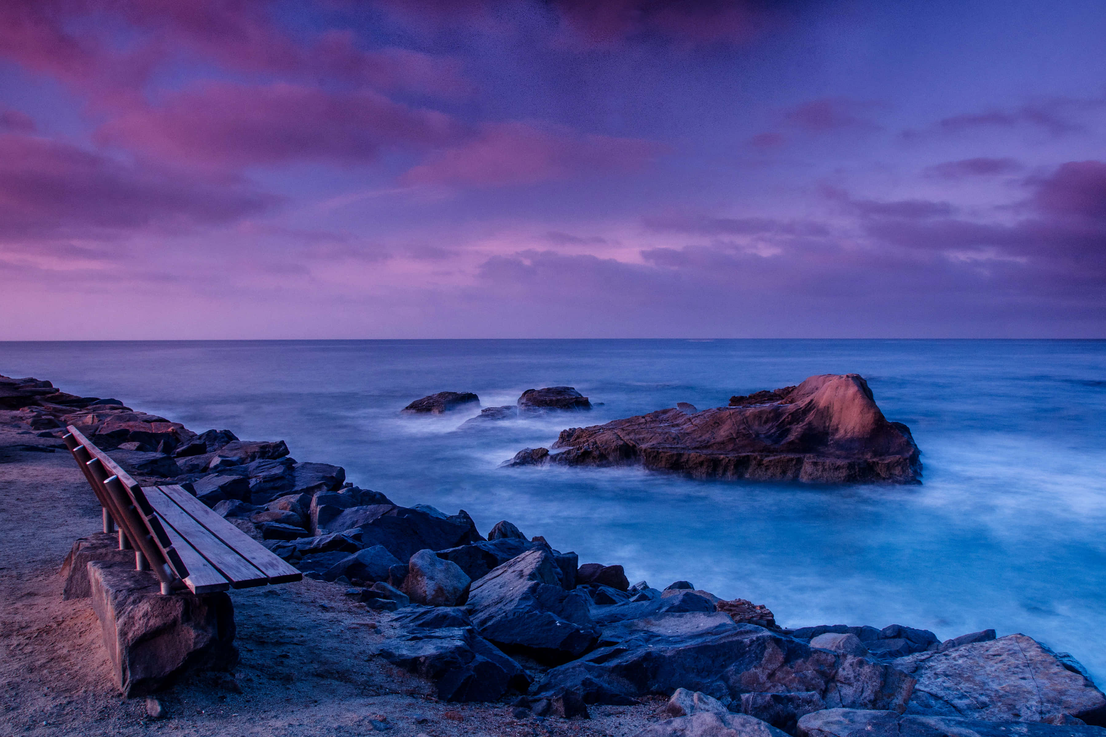 En uforglemmelig solnedgang sett fra en avsidesliggende strand Bakgrunner
