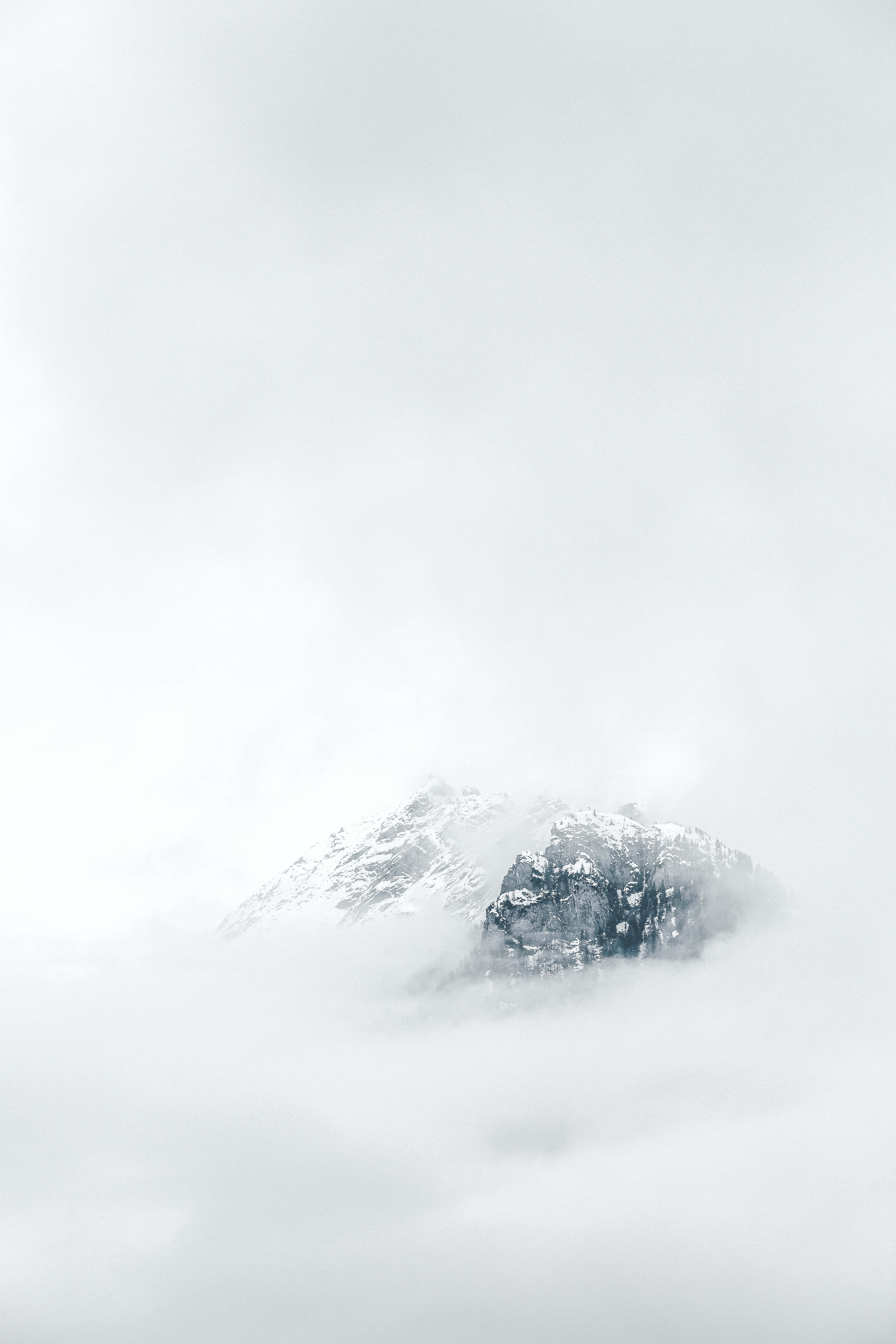et fjell dekket av skyer med snø på toppen Bakgrunner