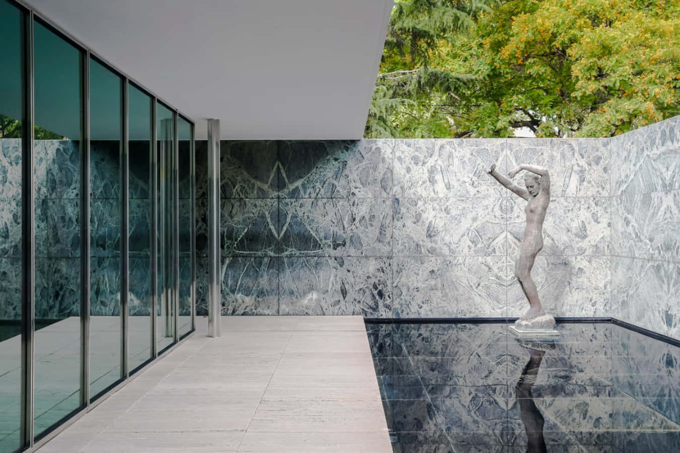 Et hus med en stor glassvegg og en statue Bakgrunner