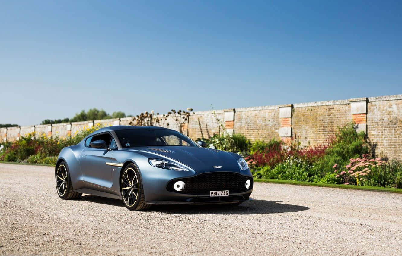 Fantastisk Aston Martin Vanquish i bevegelse på en naturskjønn vei Bakgrunner