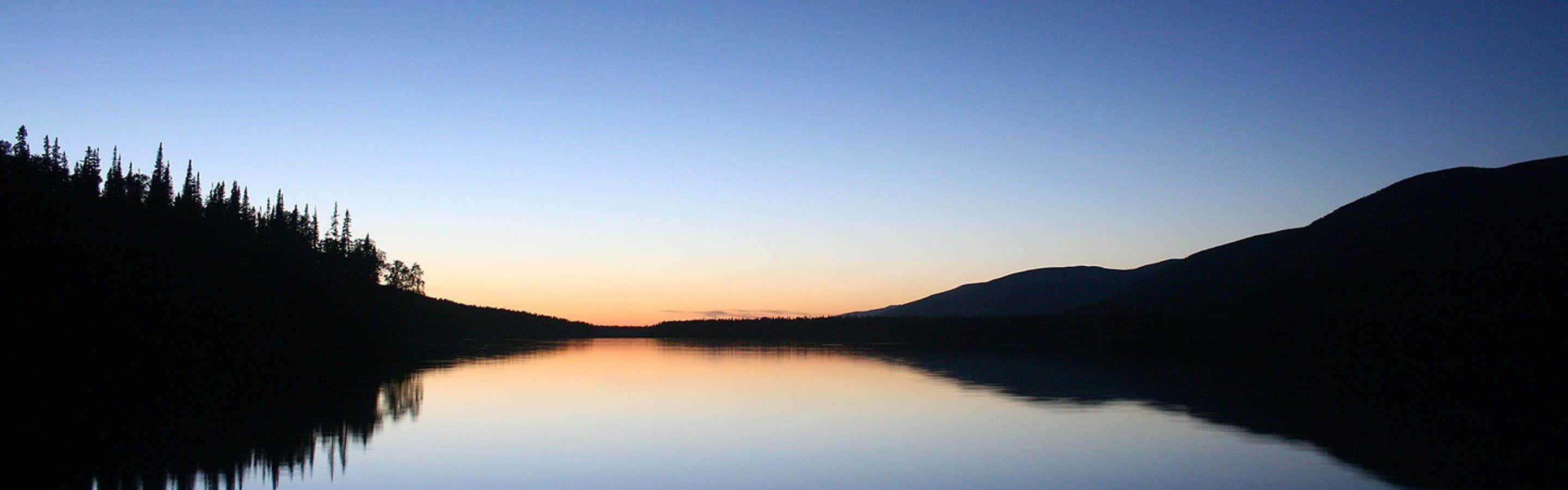 Flerskjerms rolig innsjø ved solnedgang Bakgrunner