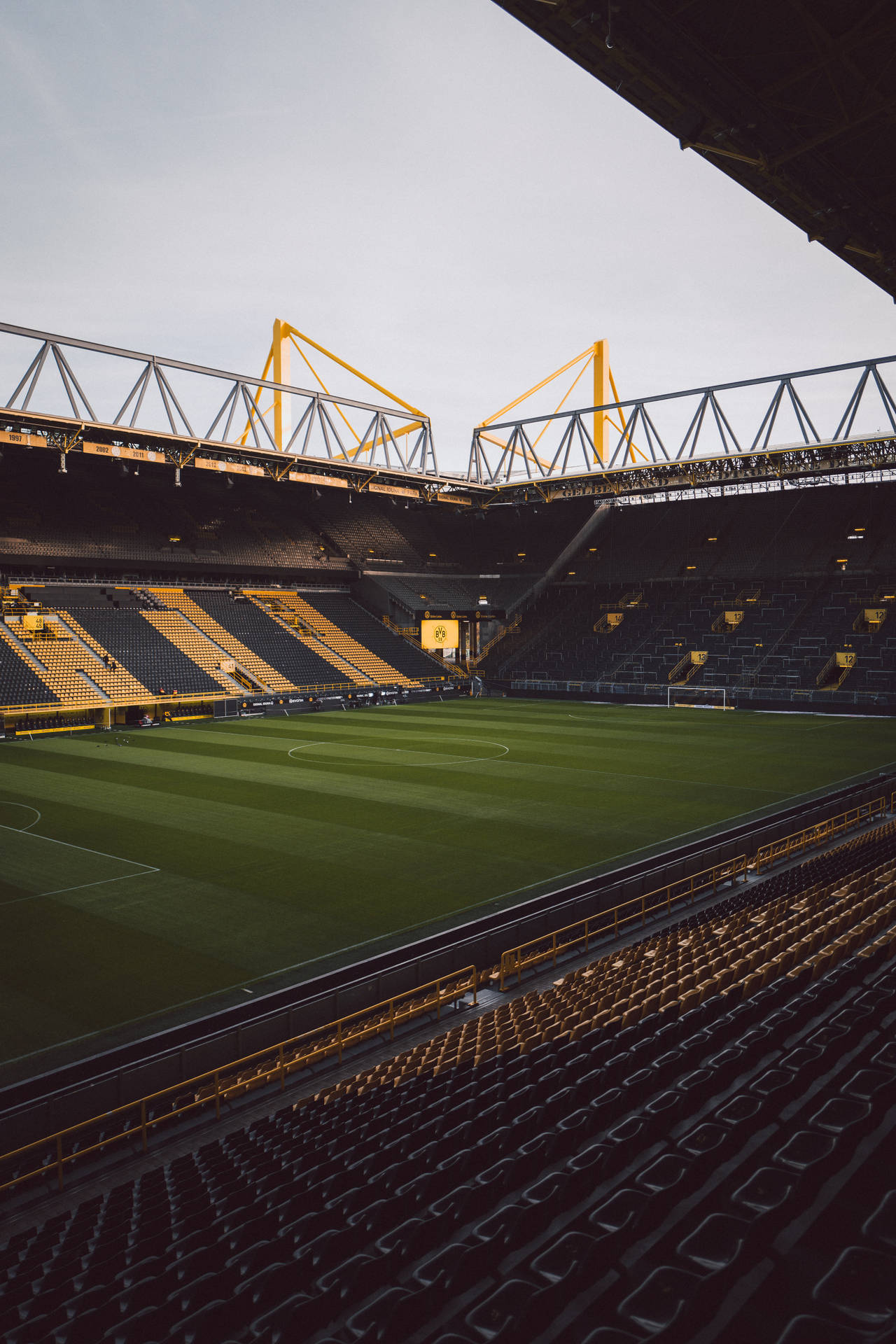 Tom fotballstadion opplyst av sollys mobilbakgrunn.