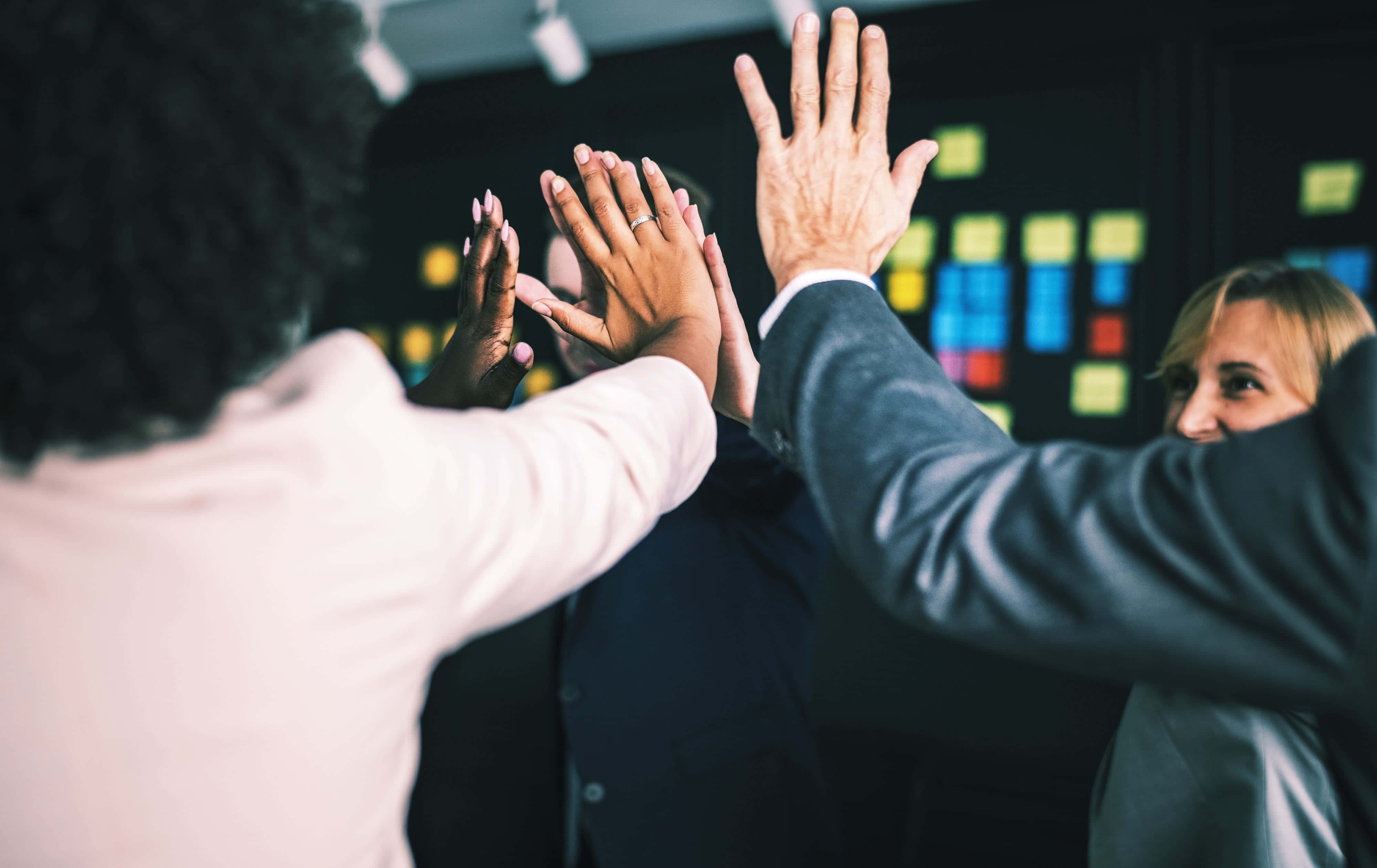 Forretningsfolk som gir high five på et kontor Bakgrunner