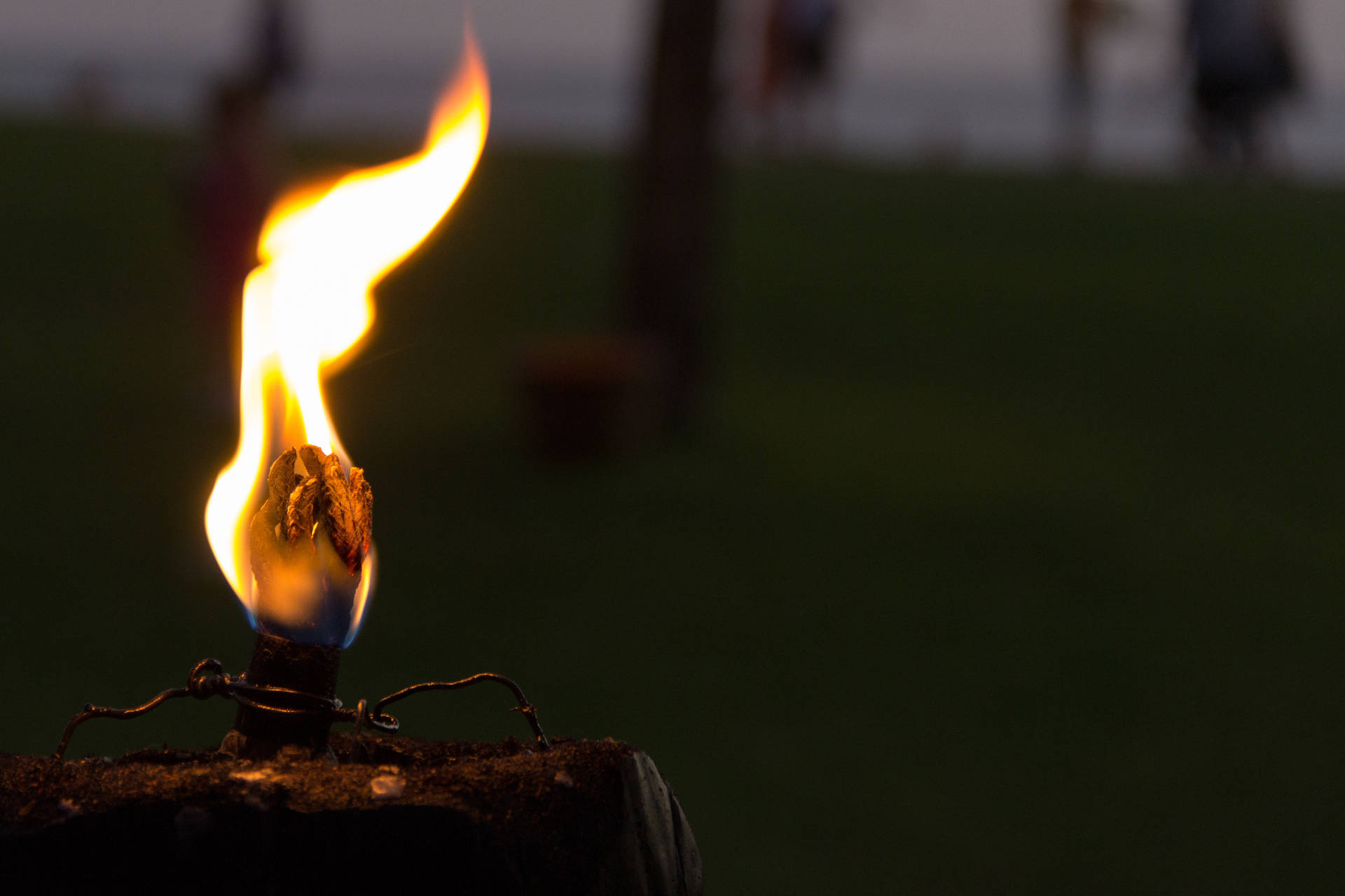 Brennende veke med sterke gule oransje flammer som opplyser de mørke omgivelsene.