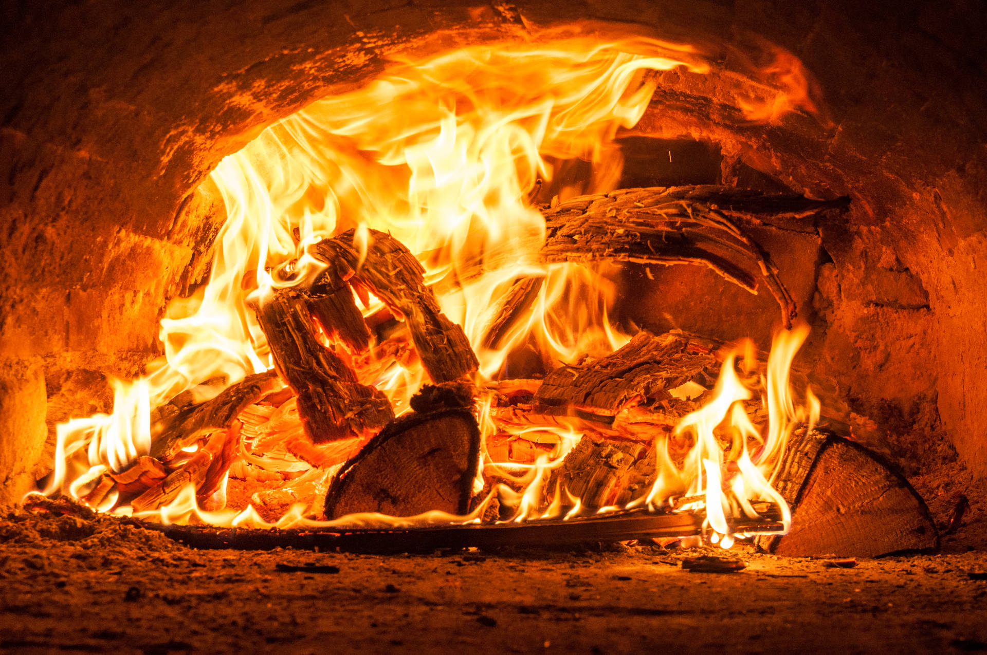 Peis med brennende ved og sterke flammer inne i en gammel liten vedovn.