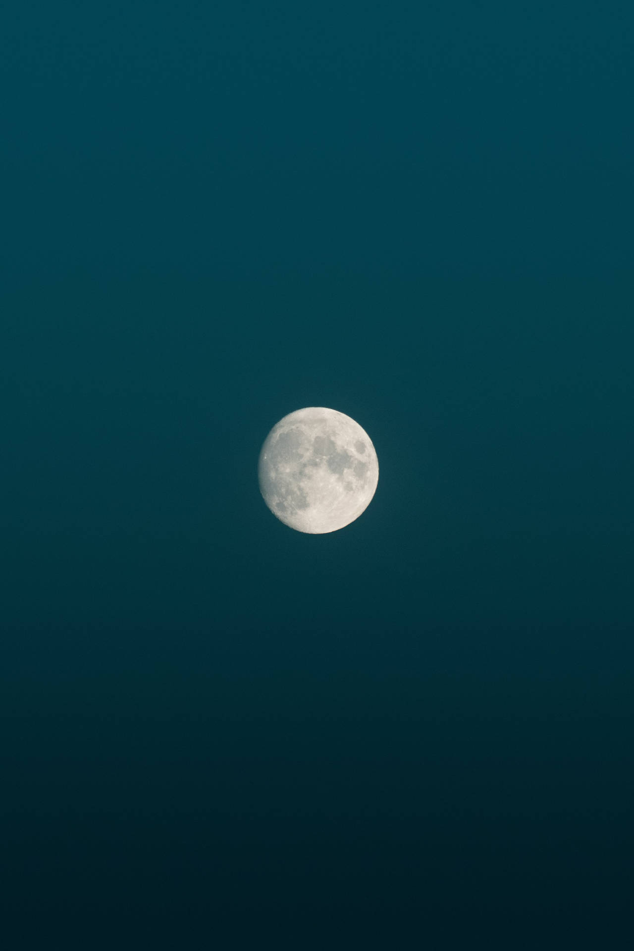 Fullmånens lysstyrke ved midnatt på en blå minimalistisk estetisk himmel. Månen og dens synlige overflate.