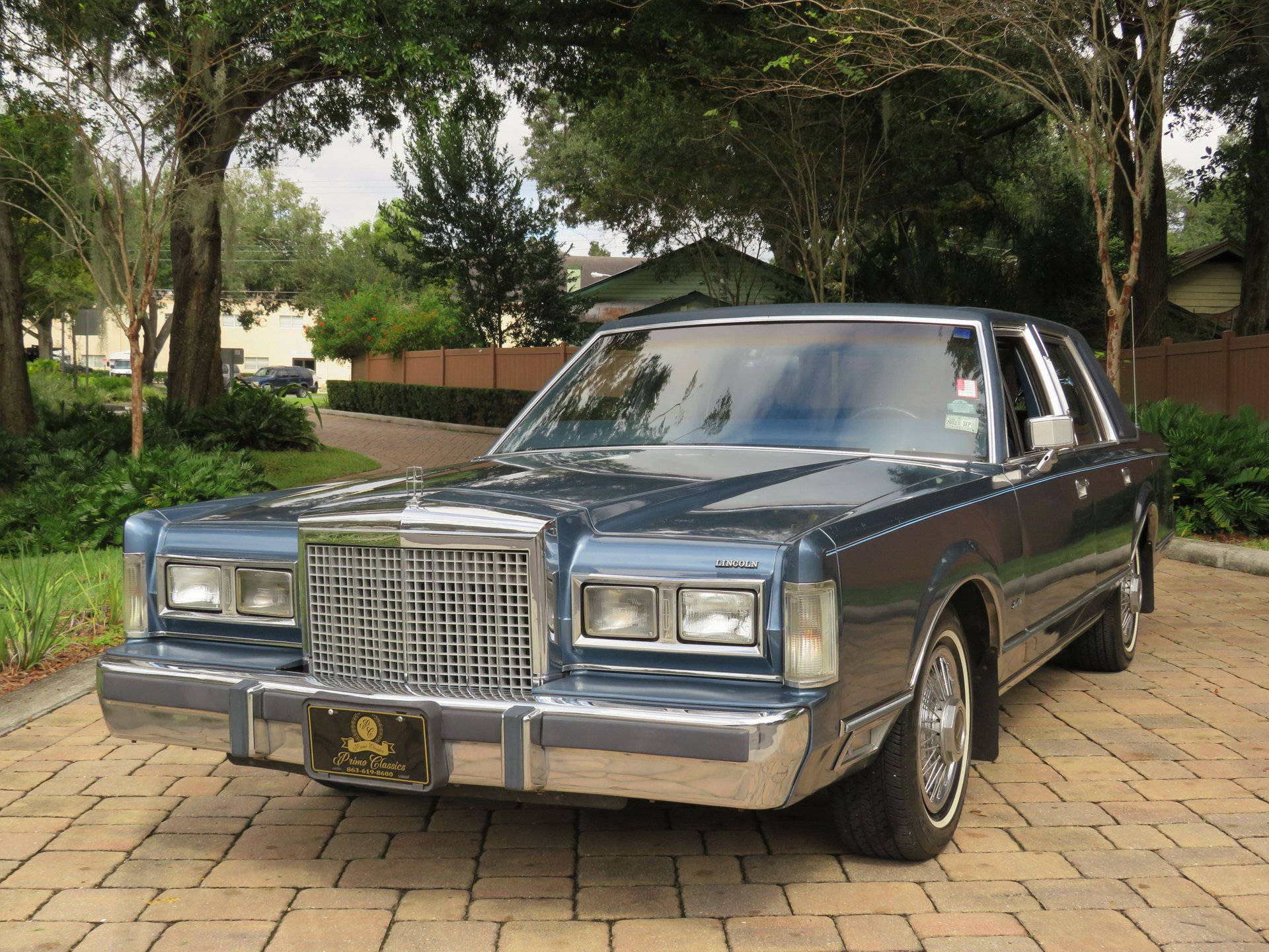 Majestetisk 1986 Lincoln Town Car parkert på asfaltert oppkjørsel Bakgrunner