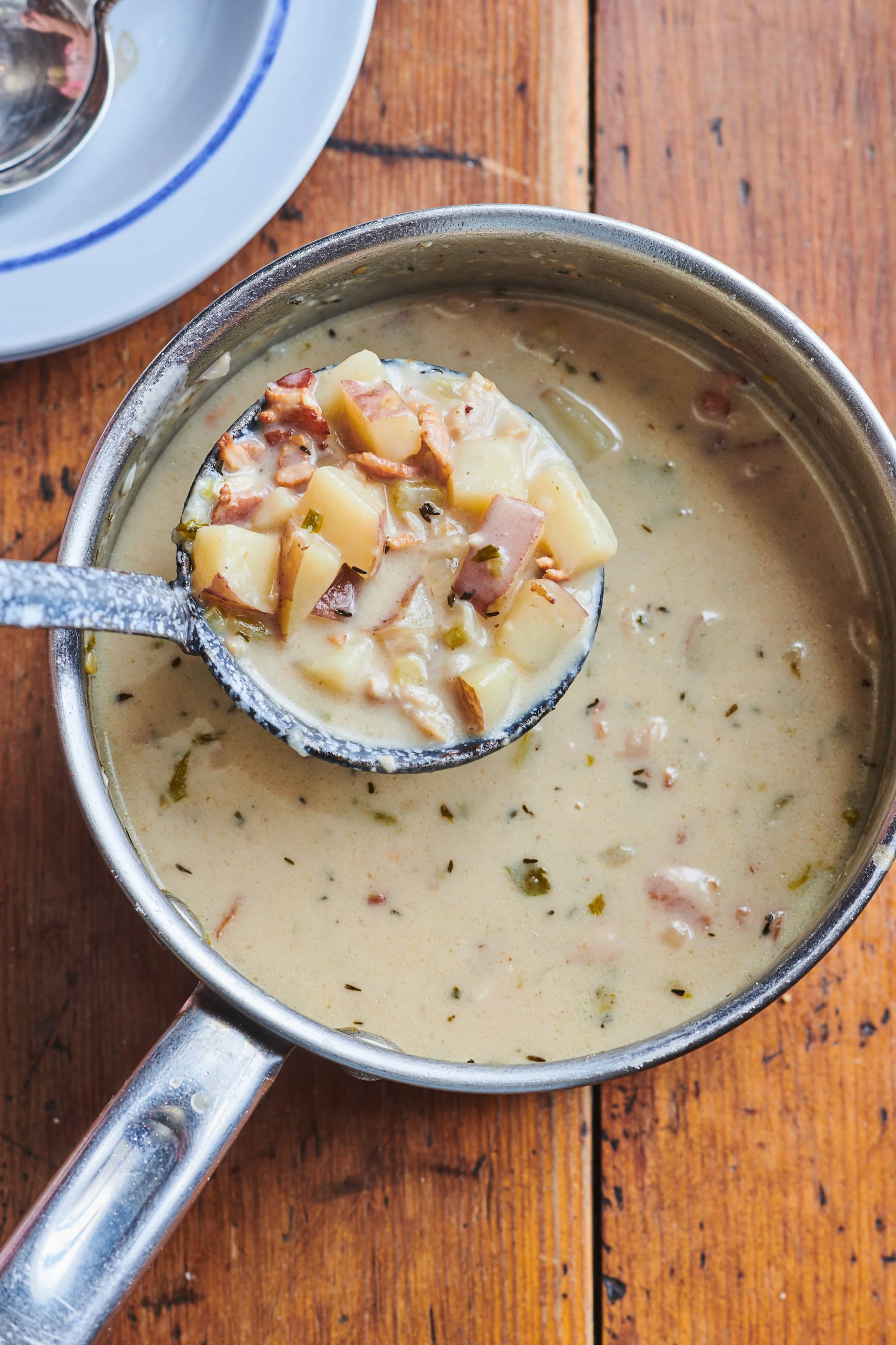 New England Clam Chowder-suppe i sølvtøysleiv Bakgrunner