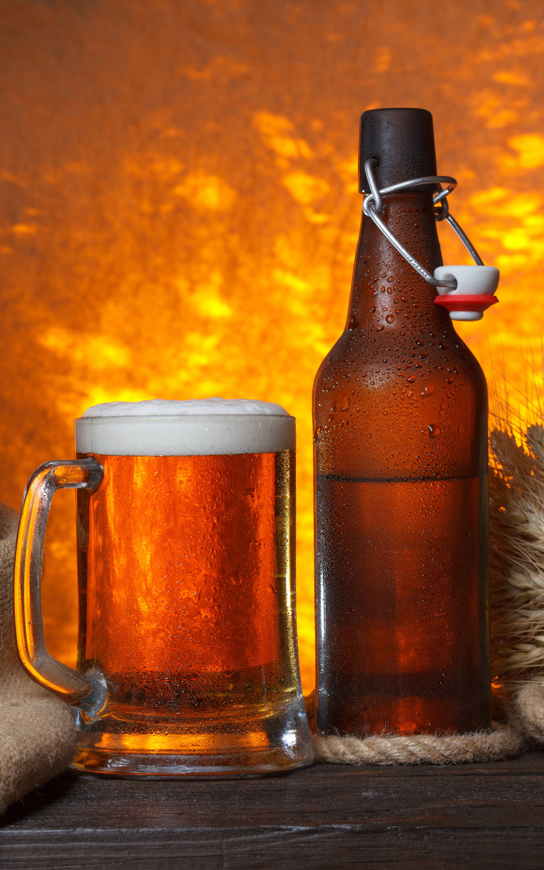 Ølflaske og halvliter med brown ale Bakgrunner