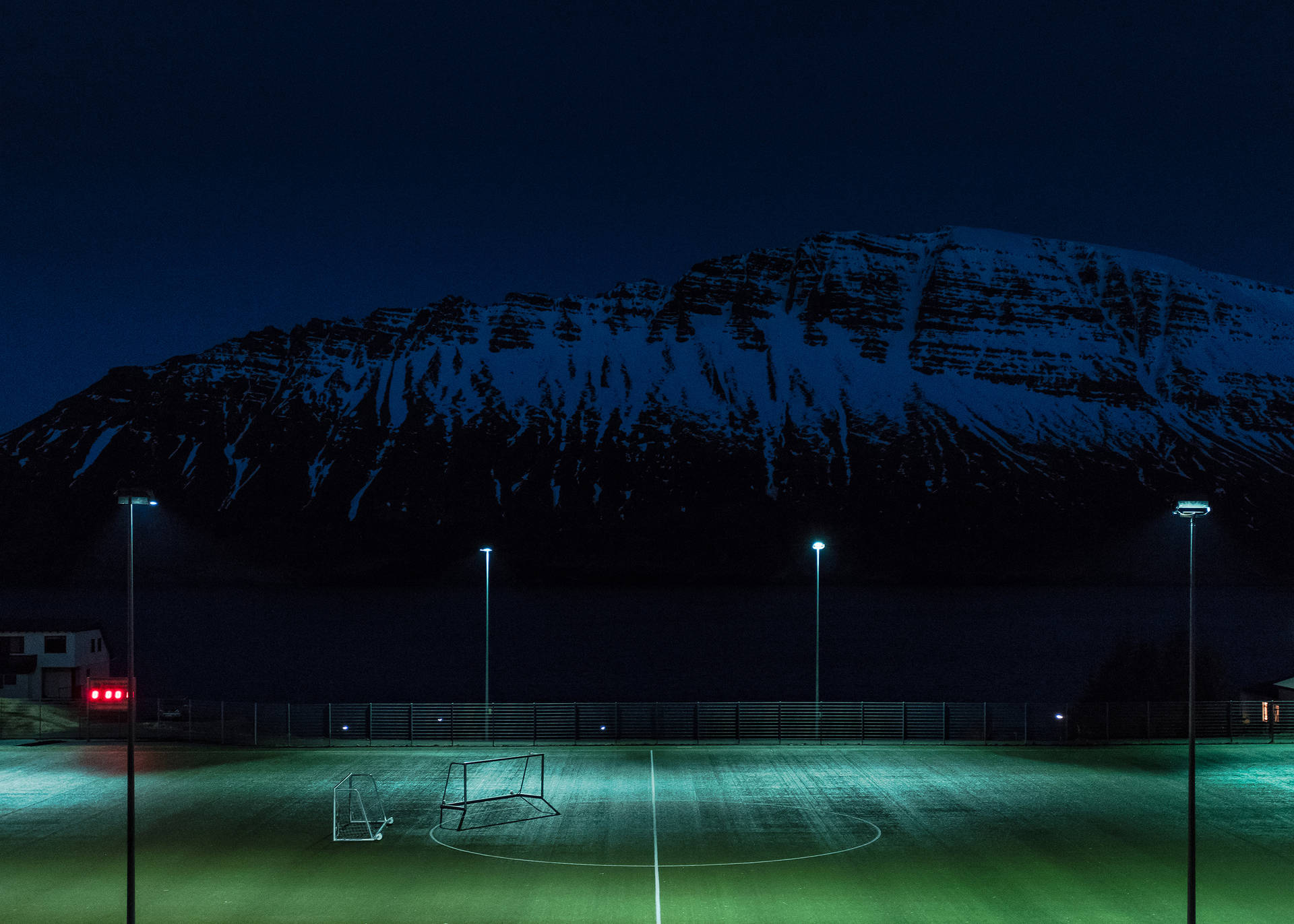 Nattfotballbane opplyst av lysstolper bakgrunn