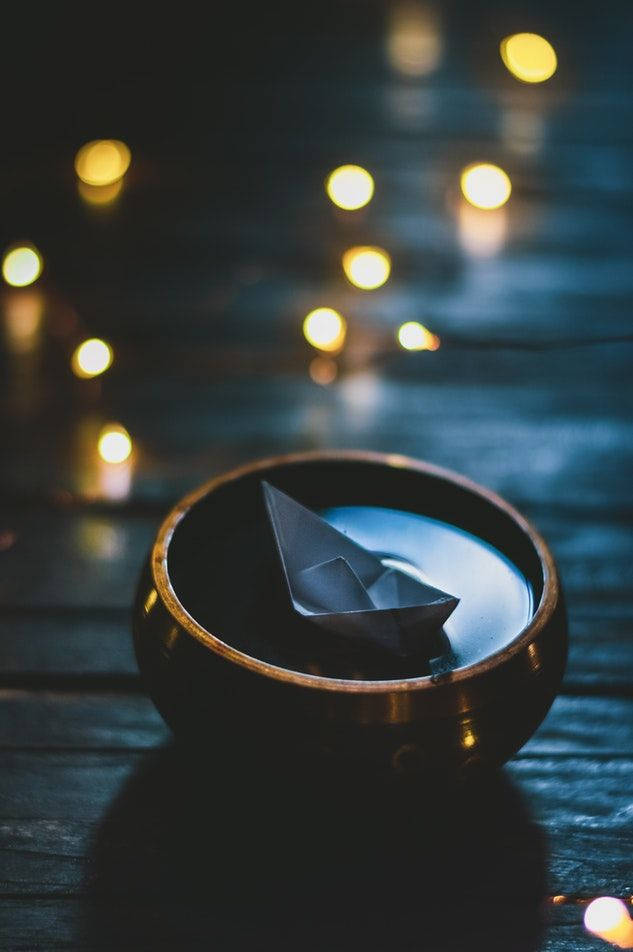 Origamibåt som flyter i bolle Bakgrunner