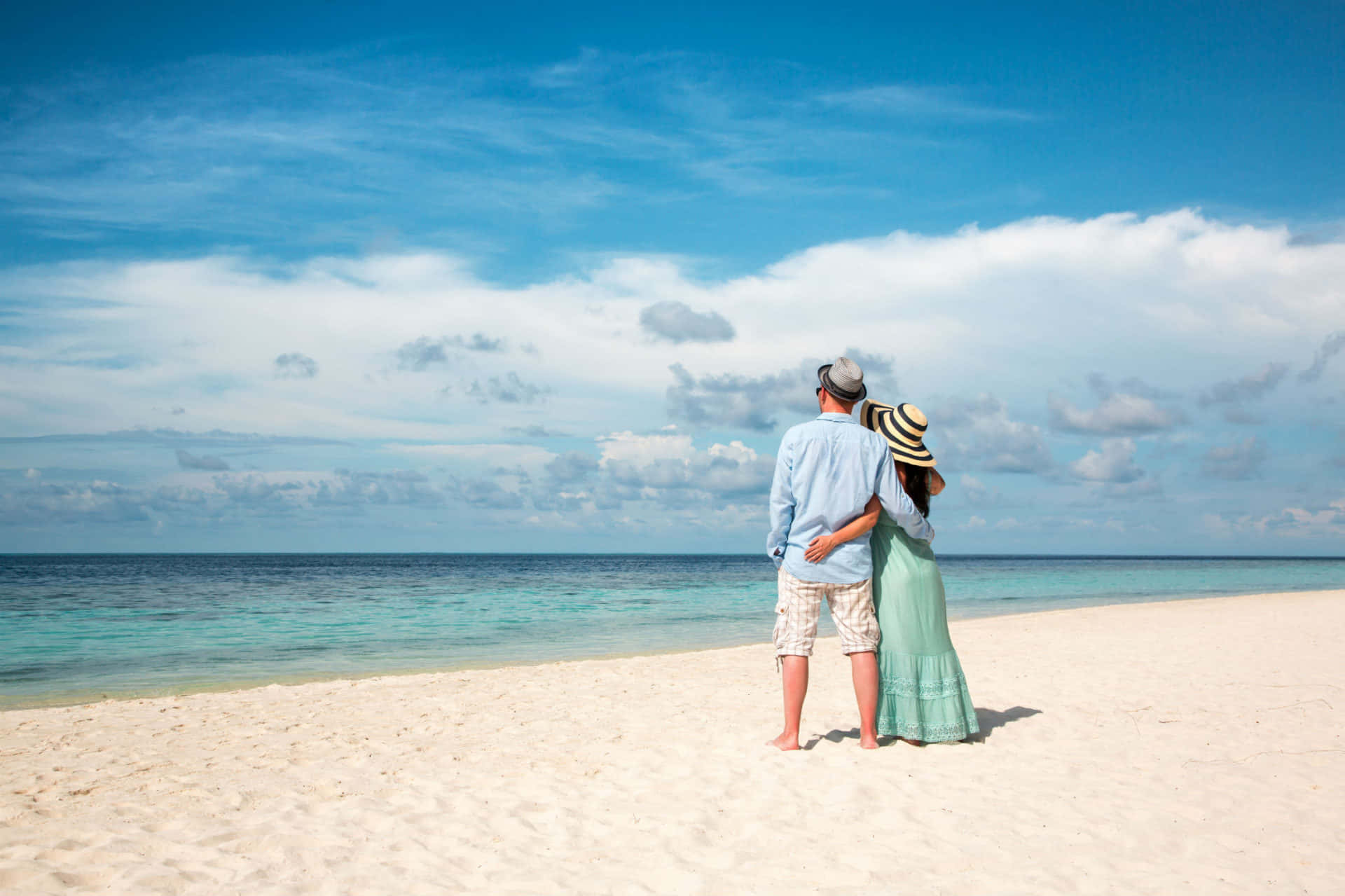 Par på stranden under blå himmel Bakgrunner