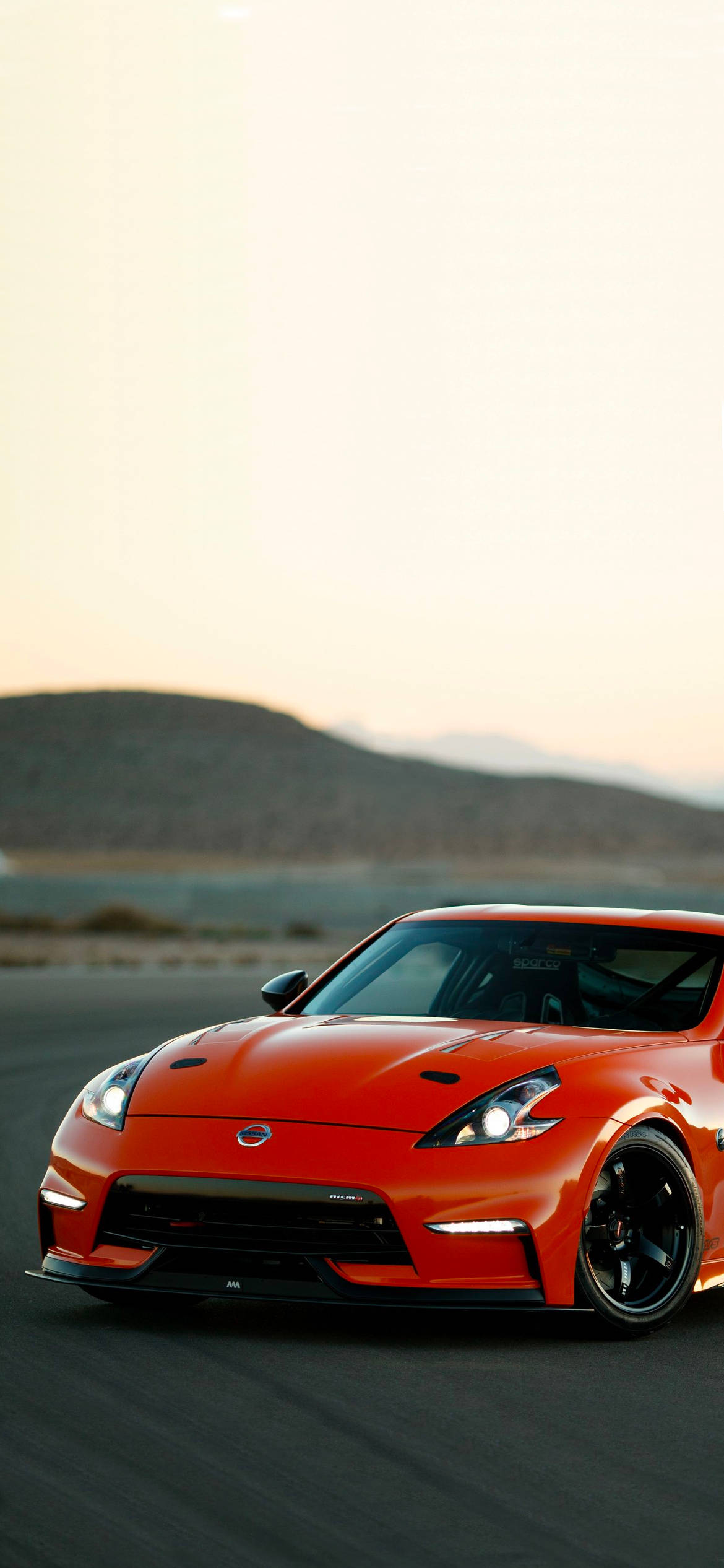 Rød Nissan 370Z Med En Ås Bakgrunner