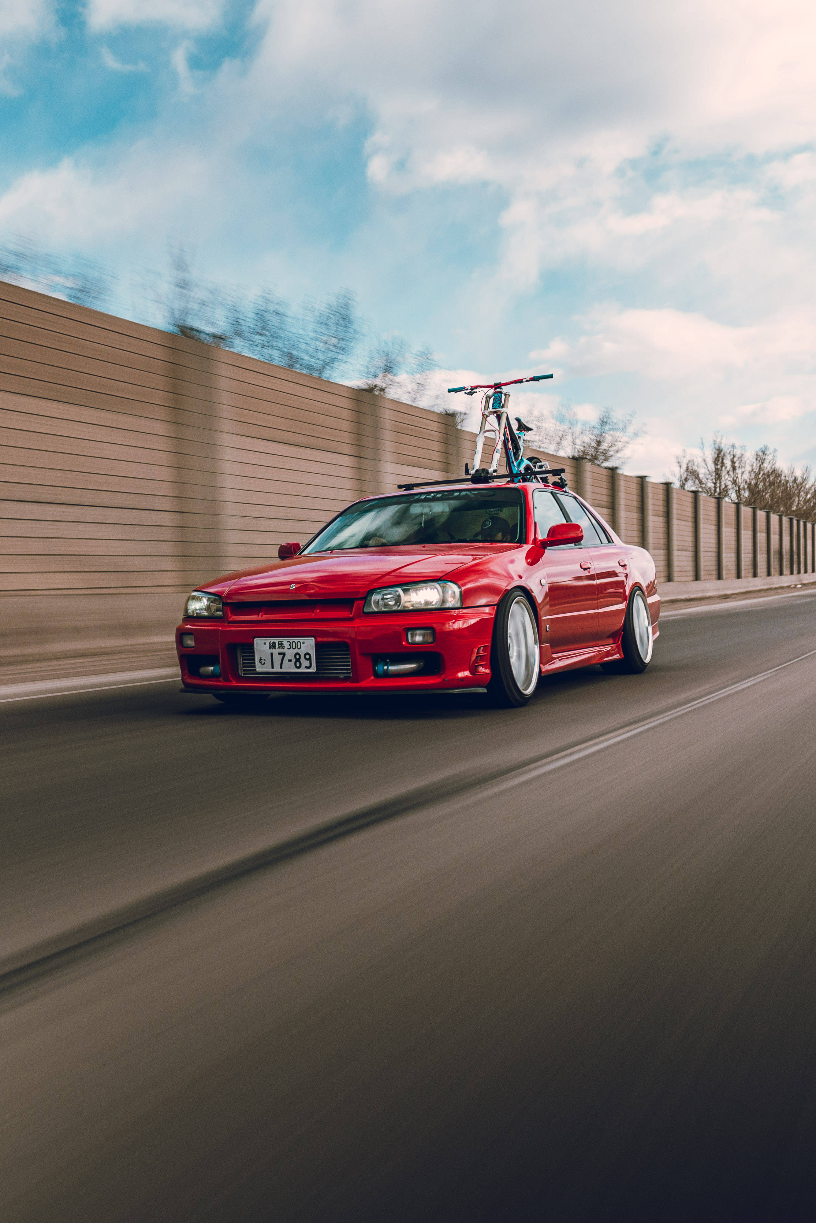 Rød Nissan Skyline GTR R34 i fart Bakgrunner