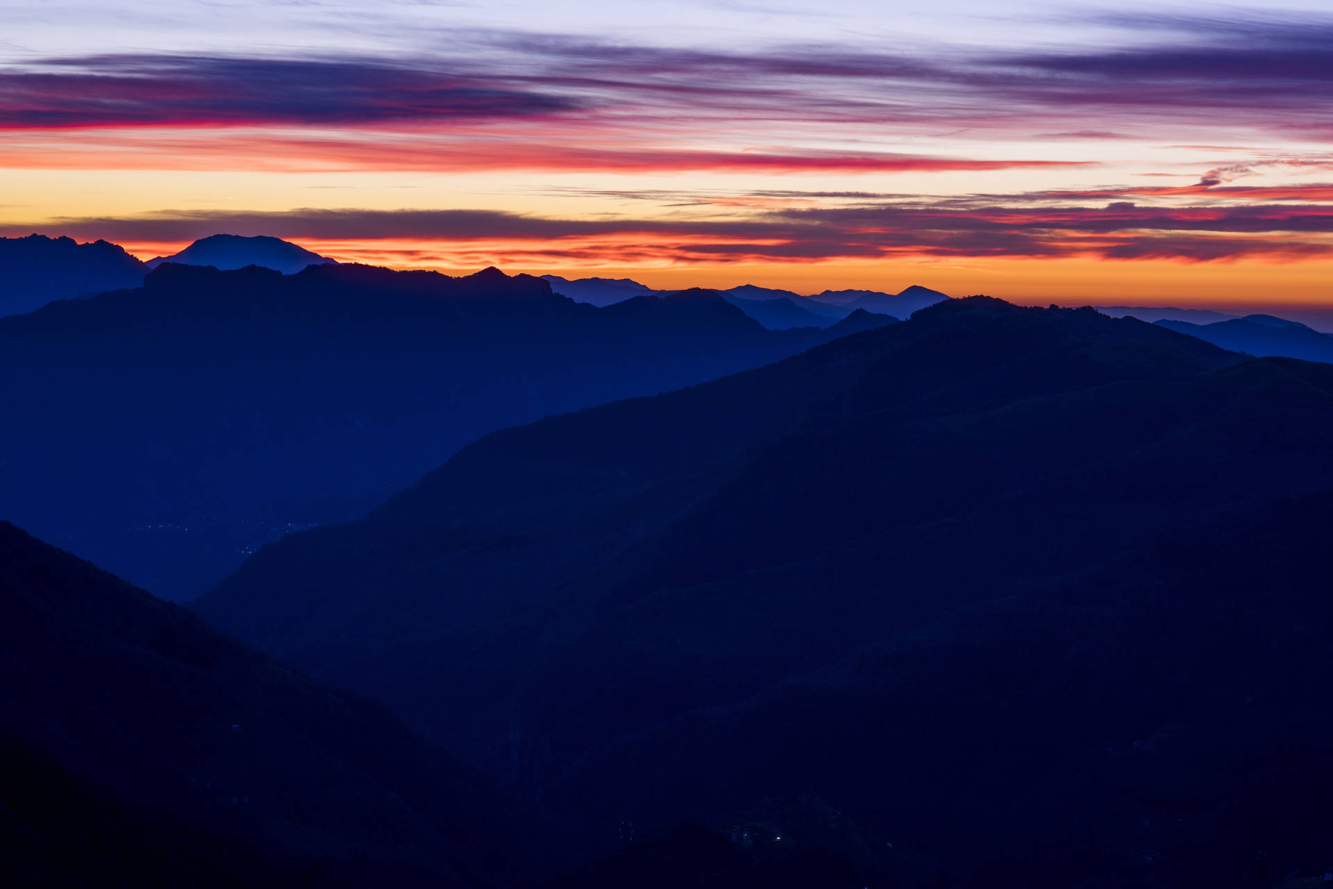 Blå fjellsolnedgang med fargerik rosa himmel.