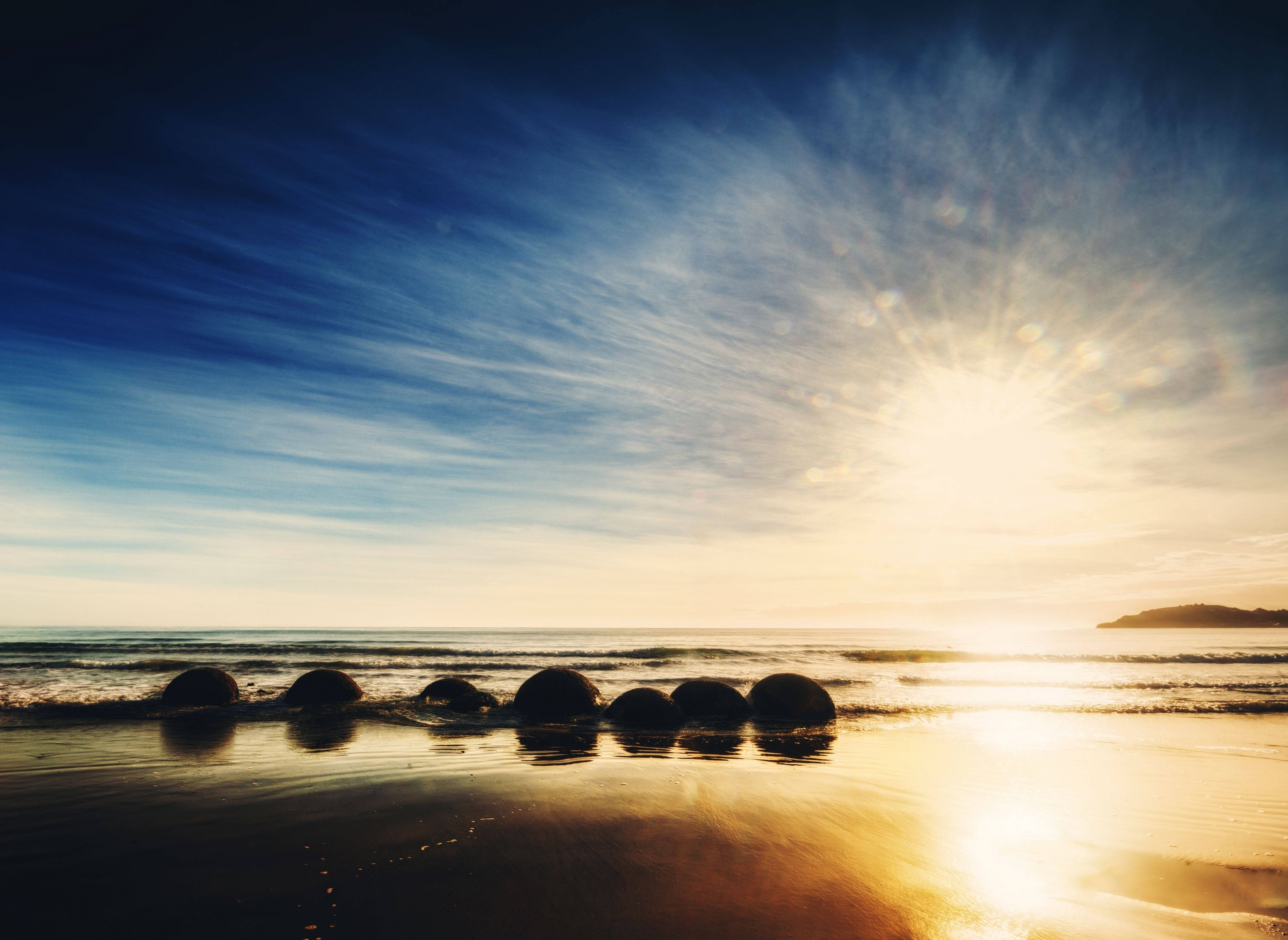 Stå opp med solen på Moeraki Boulders-stranden Bakgrunner