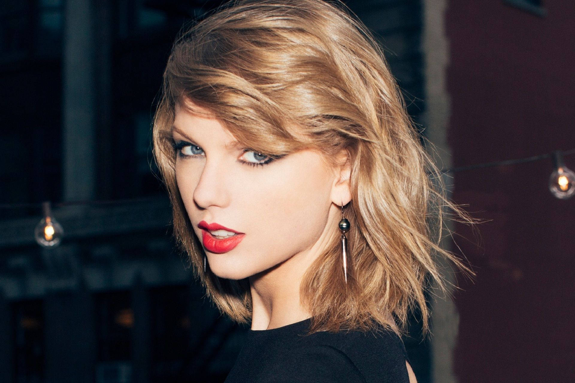 Intenst blikk Taylor Swift sidepositur bakgrunnsbilde.
