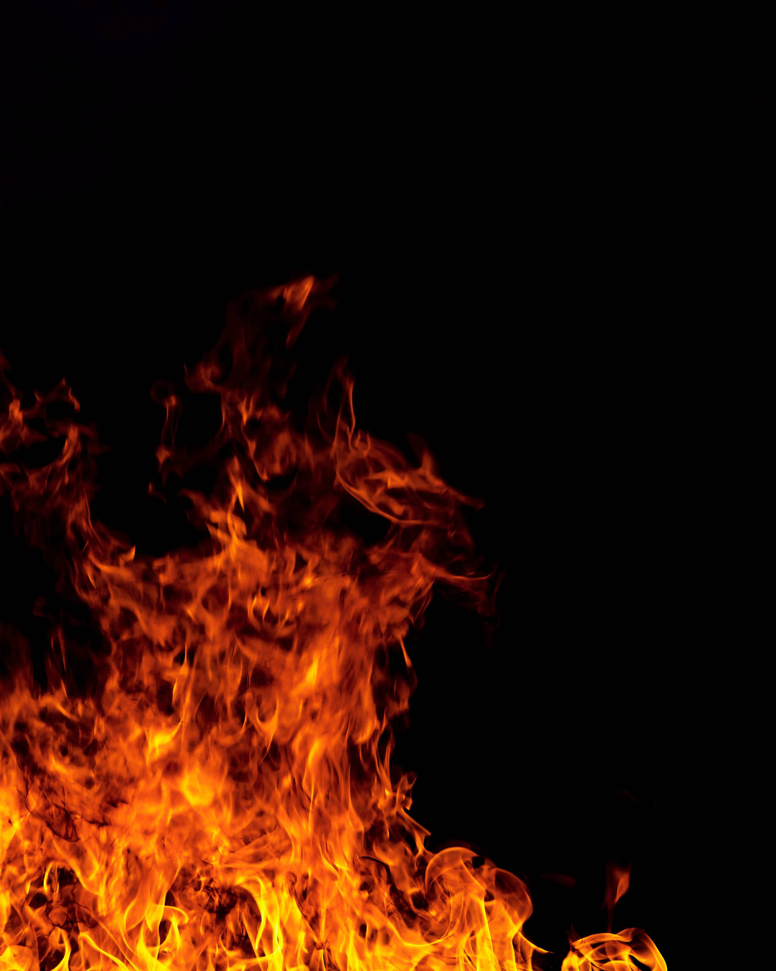 Brennende ild med røde og oransje flammer som brenner i mørket.