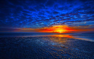 Oransje solnedgang ved stranden bakgrunnsbilde.