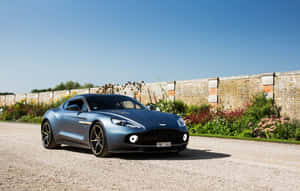 Fantastisk Aston Martin Vanquish i bevegelse på en naturskjønn vei — Steam Deck Bakgrunner