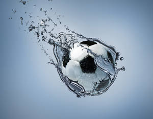 Fotball under vann grå skrivebordsbakgrunn.