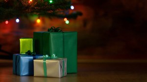 Fargerike pakker stablet under et juletre med blinkende lys. — Julegaver Bakgrunner