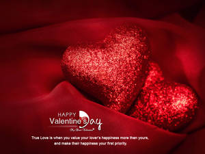 To glitrende hjerter ved siden av hverandre på mykt rødt stoff med teksten «Happy Valentine's Day» under. — 4:3 Bakgrunner
