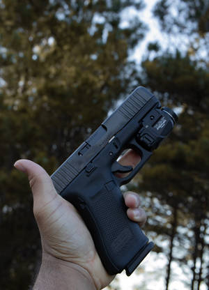 Holder en Glock med lommelykt bakgrunnsbilde — OnePlus Pad Bakgrunner