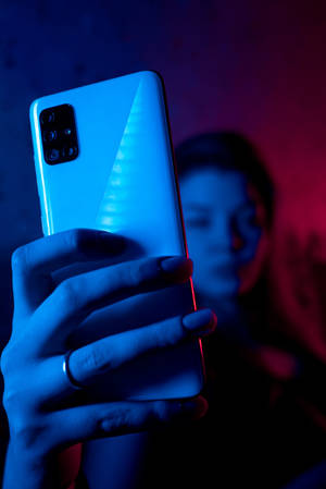 Kvinne med telefon i neonblå iPhone — Xiaomi Pad 9 Pro Max Bakgrunner