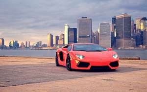 Bilbakgrunnsbilde av en rød Lamborghini Aventador i Brooklyn Bridge Park.