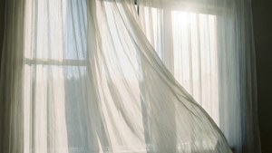 Hvite, lette gardiner som blåser i sollys, et beroligende og eterisk bakgrunnsbilde. — Hvit estetikk Bakgrunner